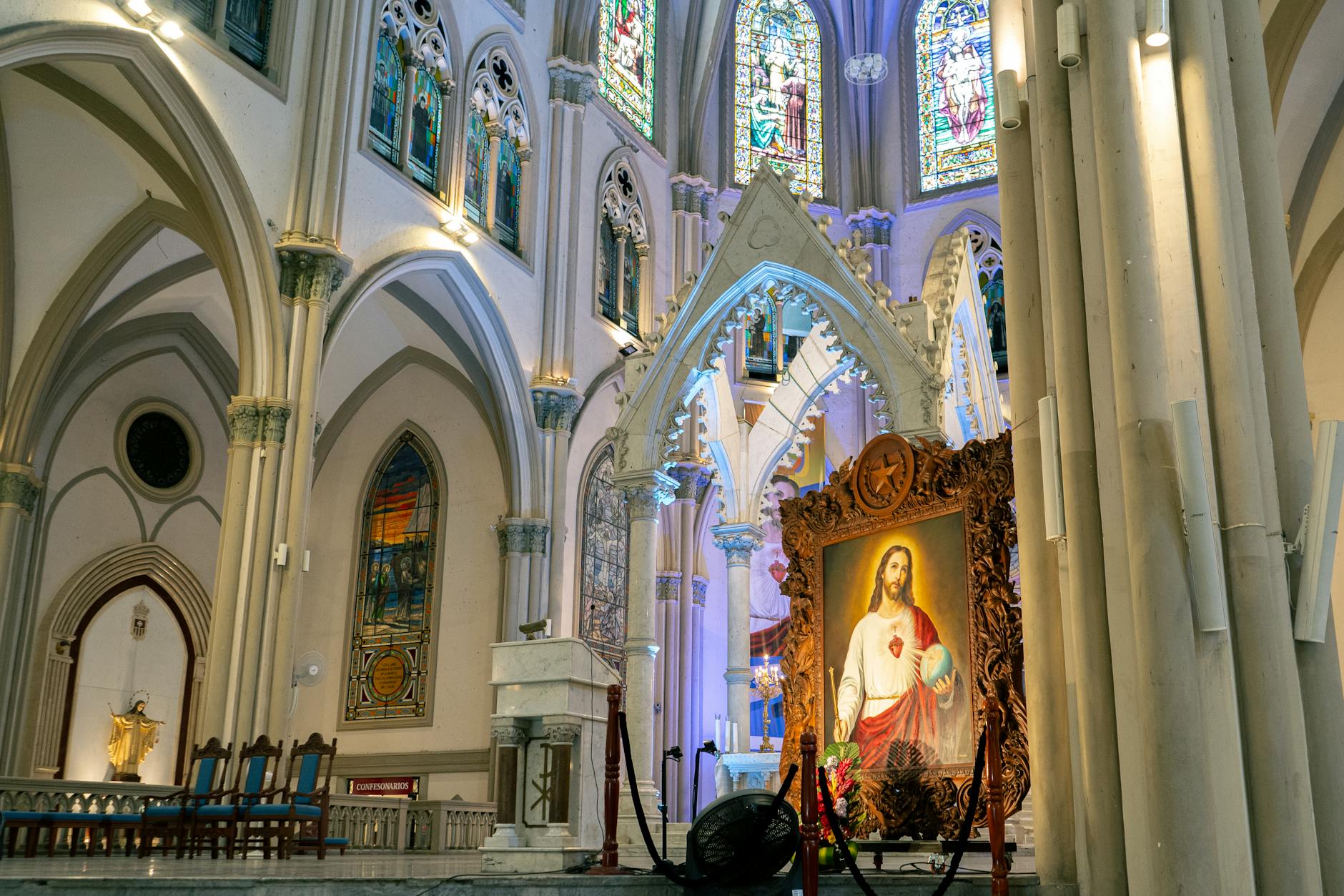 A beautiful view of a church's interior in Guayaquil featuring stained glass windows and religious art.