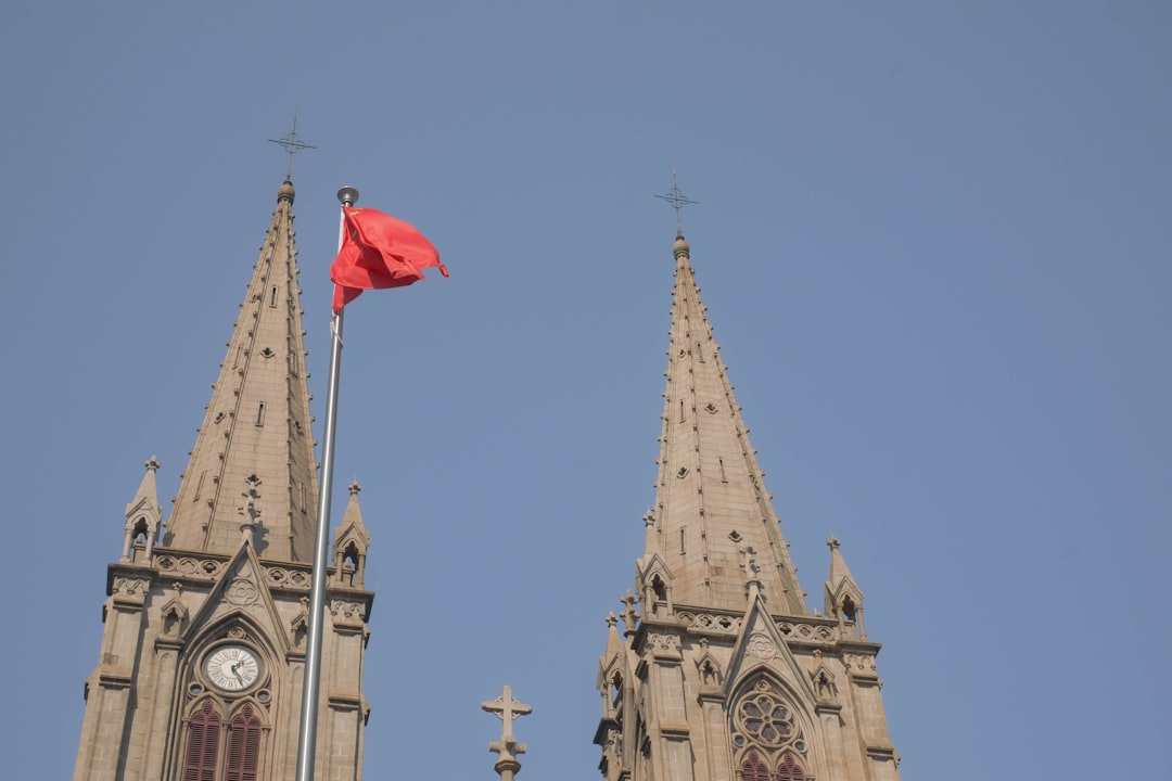 Two gothic spires with a red flag flying