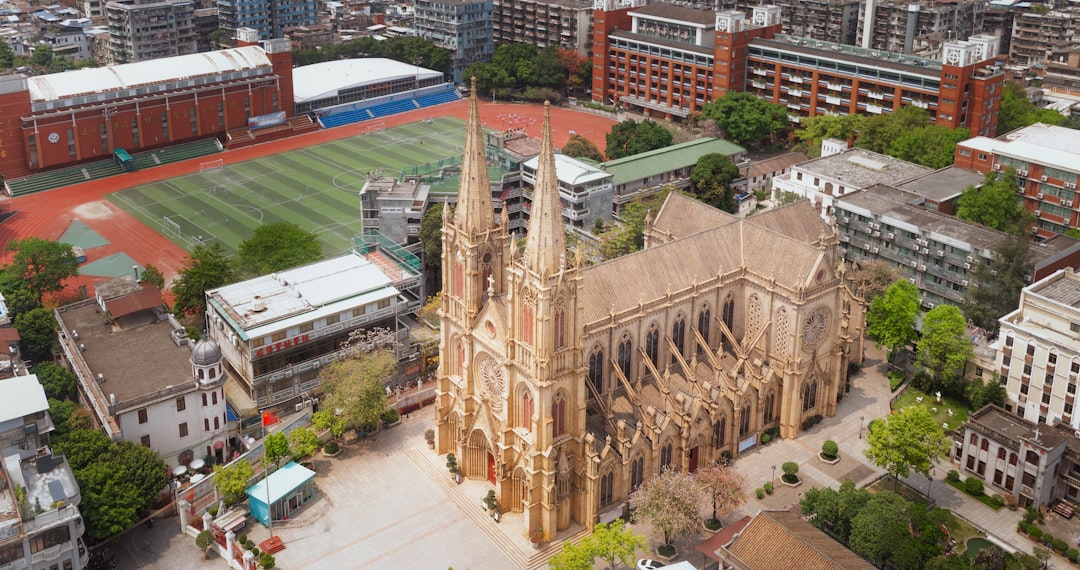 Church with two spires, near a sports field.