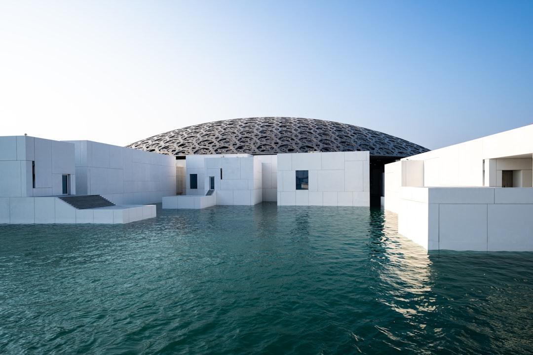 Modern white building with a domed roof and water