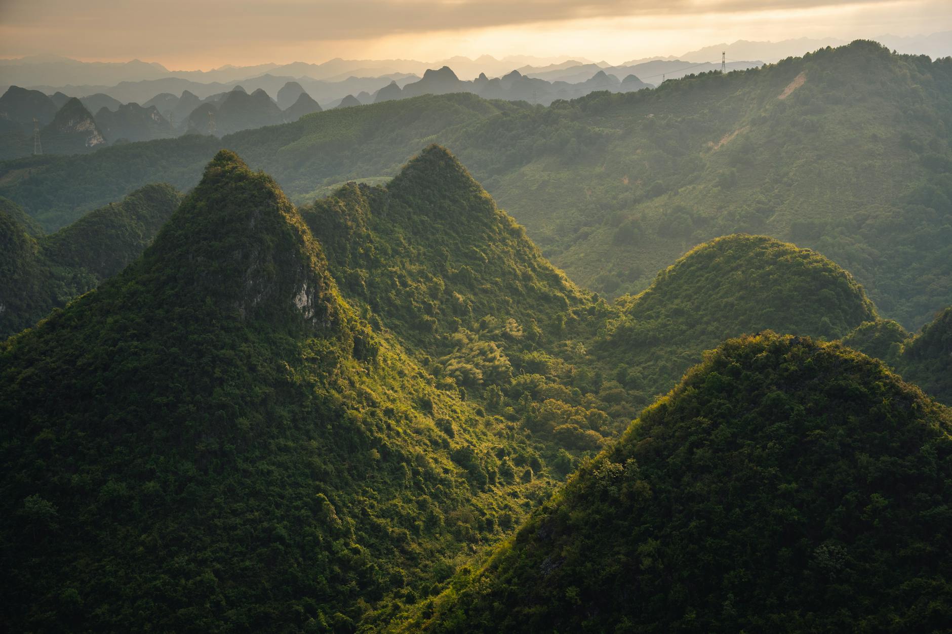 Stunning aerial view of lush green karst mountain landscape in Guilin, Guangxi, China during sunset.