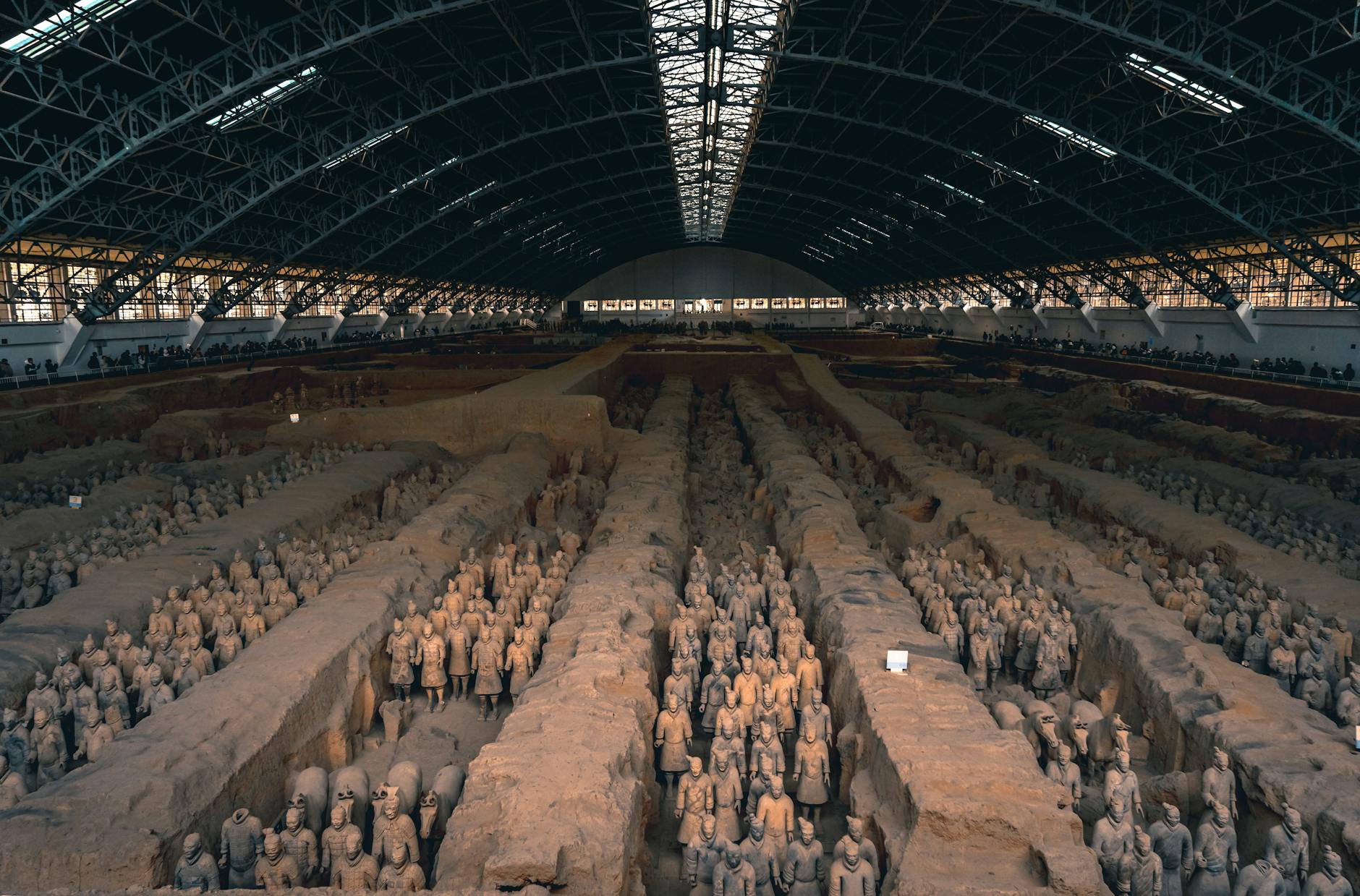 The iconic Terracotta Army in Xi'an, China, displayed within a grand indoor museum setting.