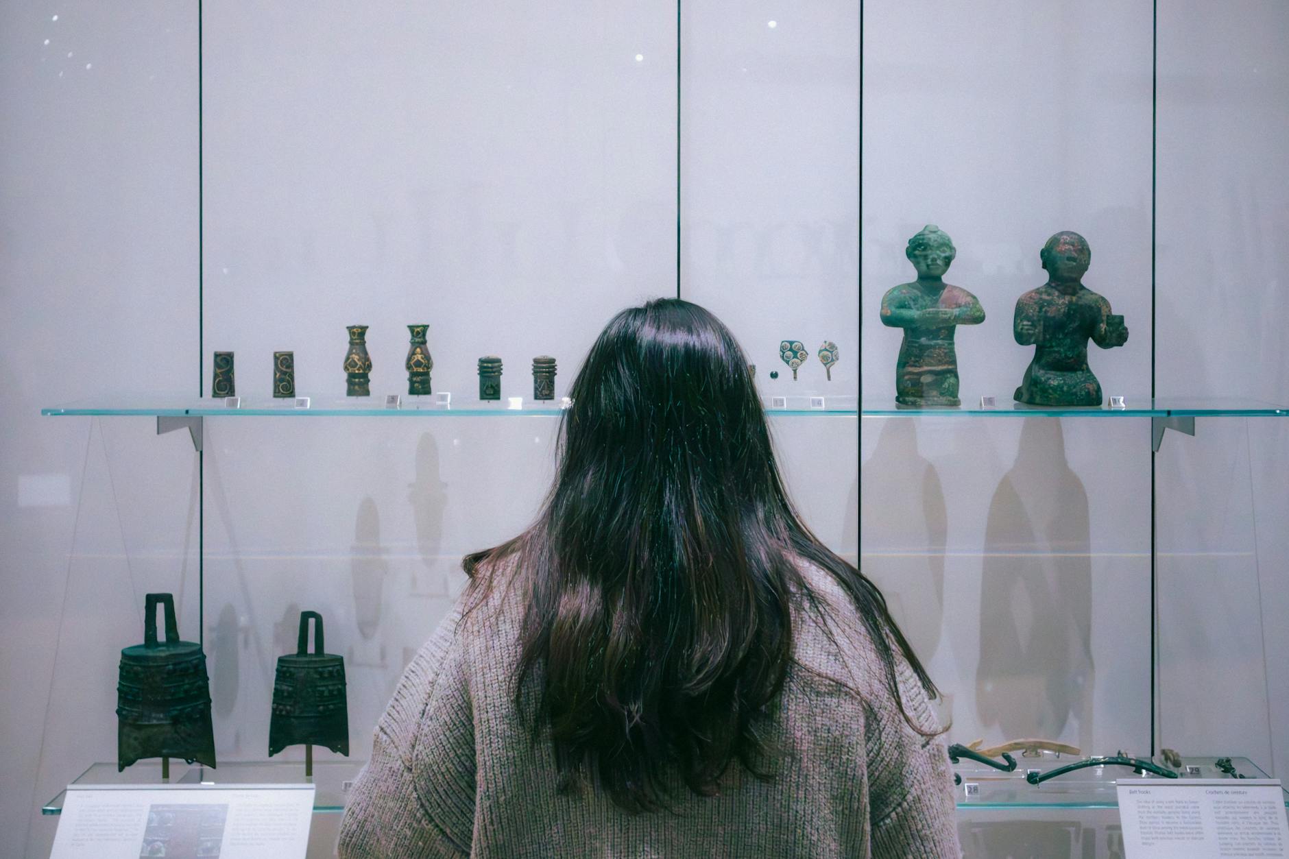 A person views ancient sculptures in a Toronto museum exhibit.