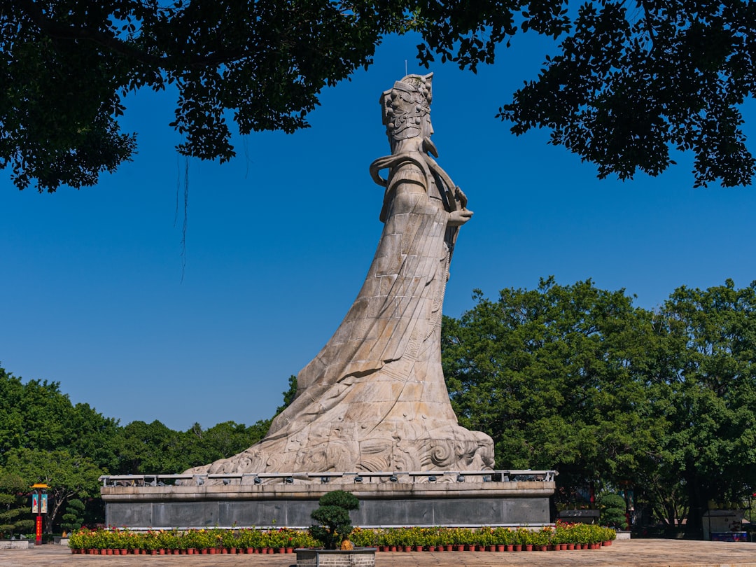Large stone statue of a woman against blue sky