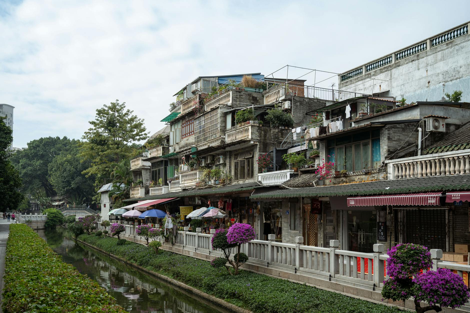 Charming street in Guangzhou showcasing traditional architecture and a scenic canal view.