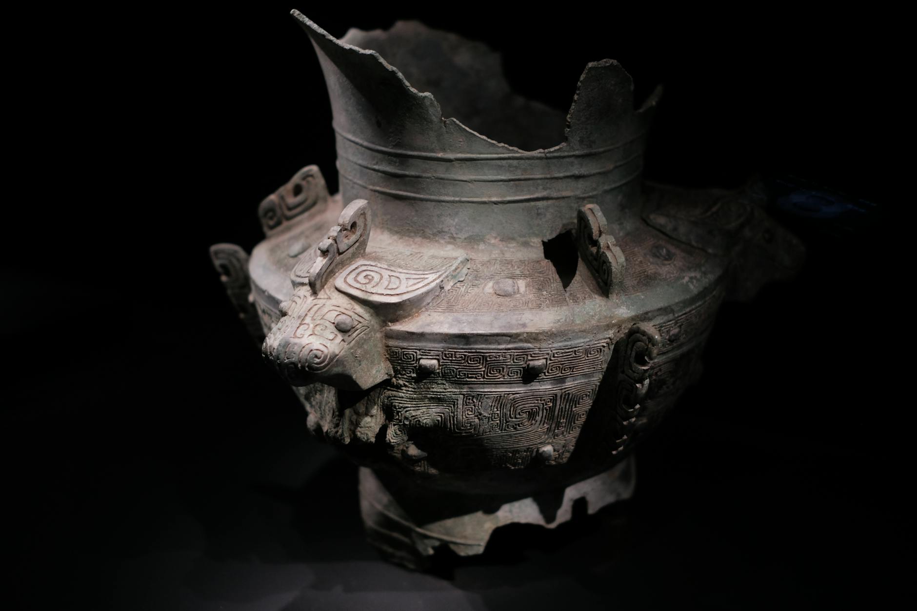Intricate ancient Chinese bronze vessel with decorative patterns and animal motifs on display.
