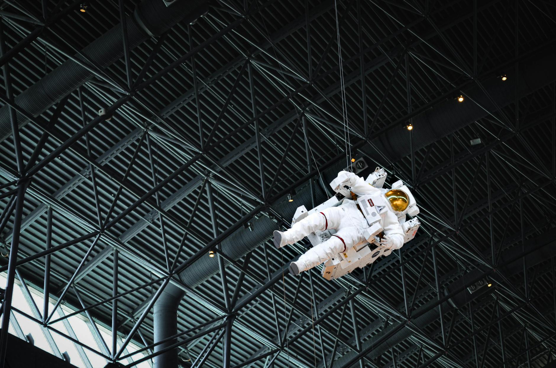 Astronaut model suspended within the Chantilly Air and Space Museum exhibit showcasing space exploration history.