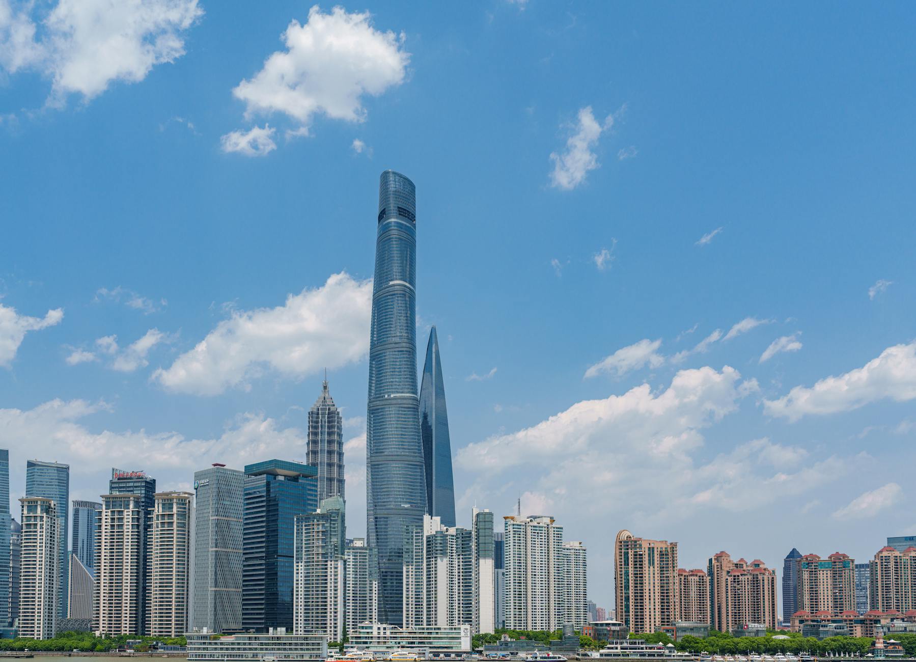 A vibrant view of the Shanghai skyline featuring iconic skyscrapers under a clear blue sky.