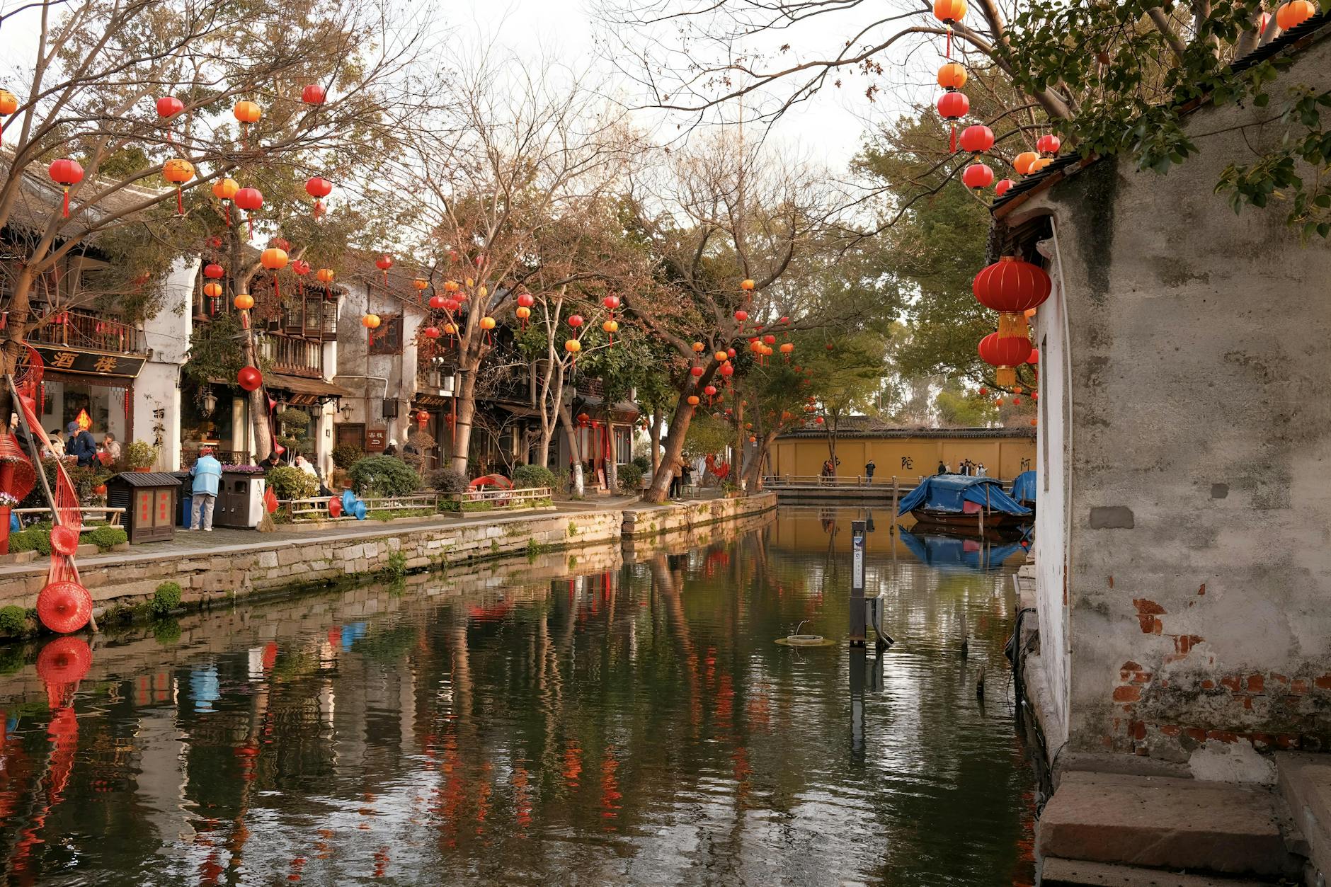 Charming Suzhou canal scene with red lanterns and reflections, capturing the essence of traditional Chinese architecture.