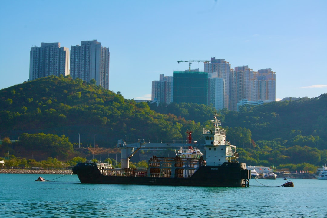 black ship on sea near city buildings during daytime
