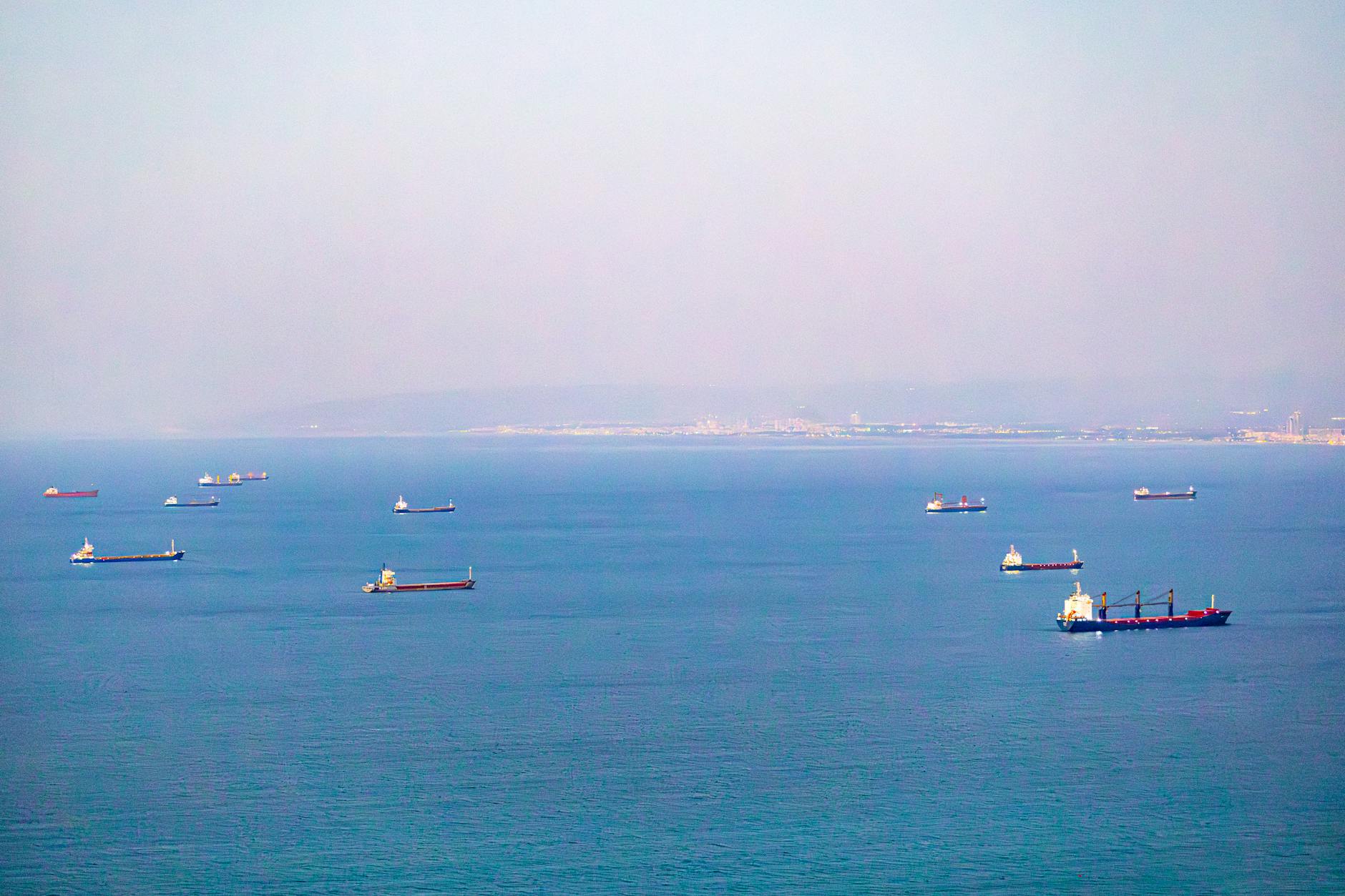Aerial view of cargo ships in Haifa Bay, Israel. Calm sea and clear sky.