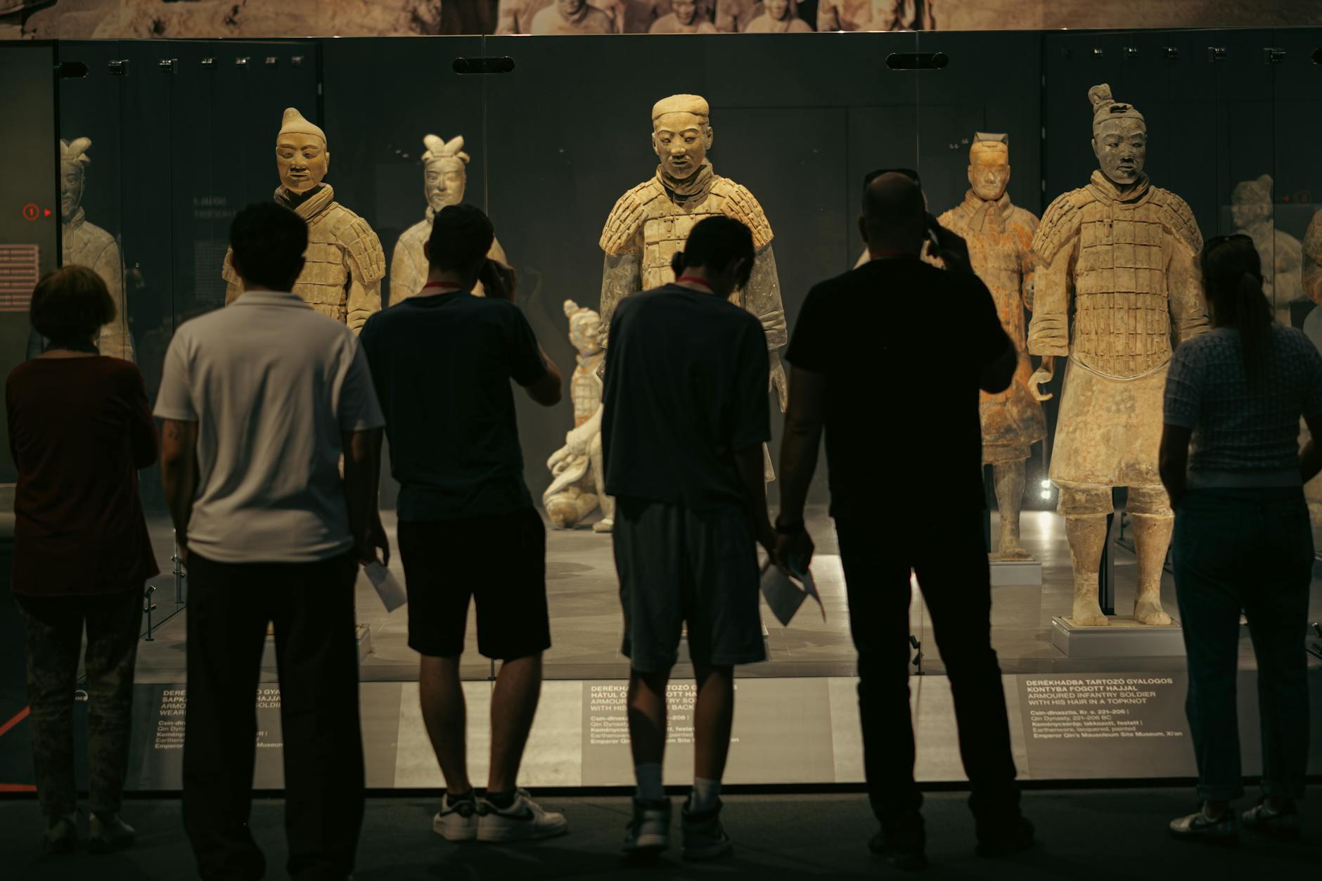 People observing the Terracotta Warriors exhibit at a museum in Budapest, Hungary.