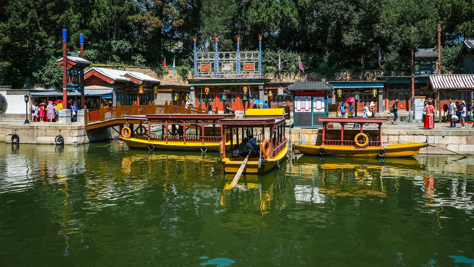 Explore traditional boats along a scenic waterway in Beijing, China, capturing vibrant architectural charm.
