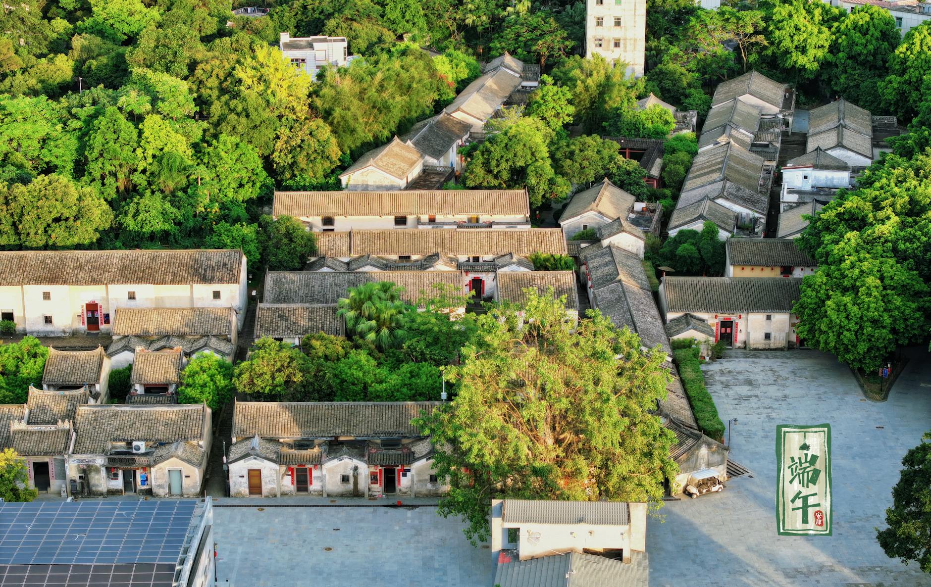 Aerial view of traditional Chinese courtyard houses amid lush greenery in Shenzhen, China.