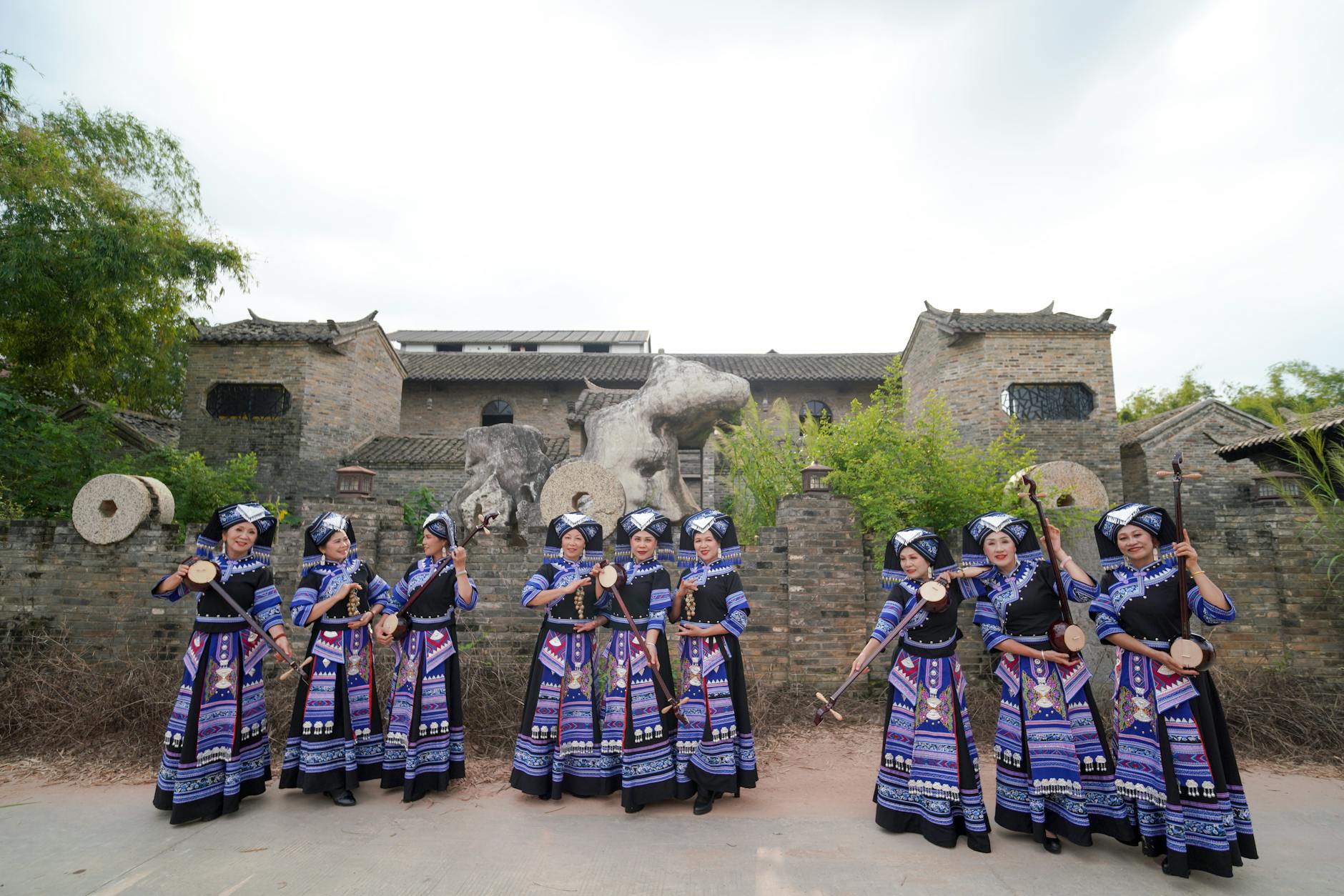Zhuang women in vibrant ethnic costumes performing traditional music in Guangxi.