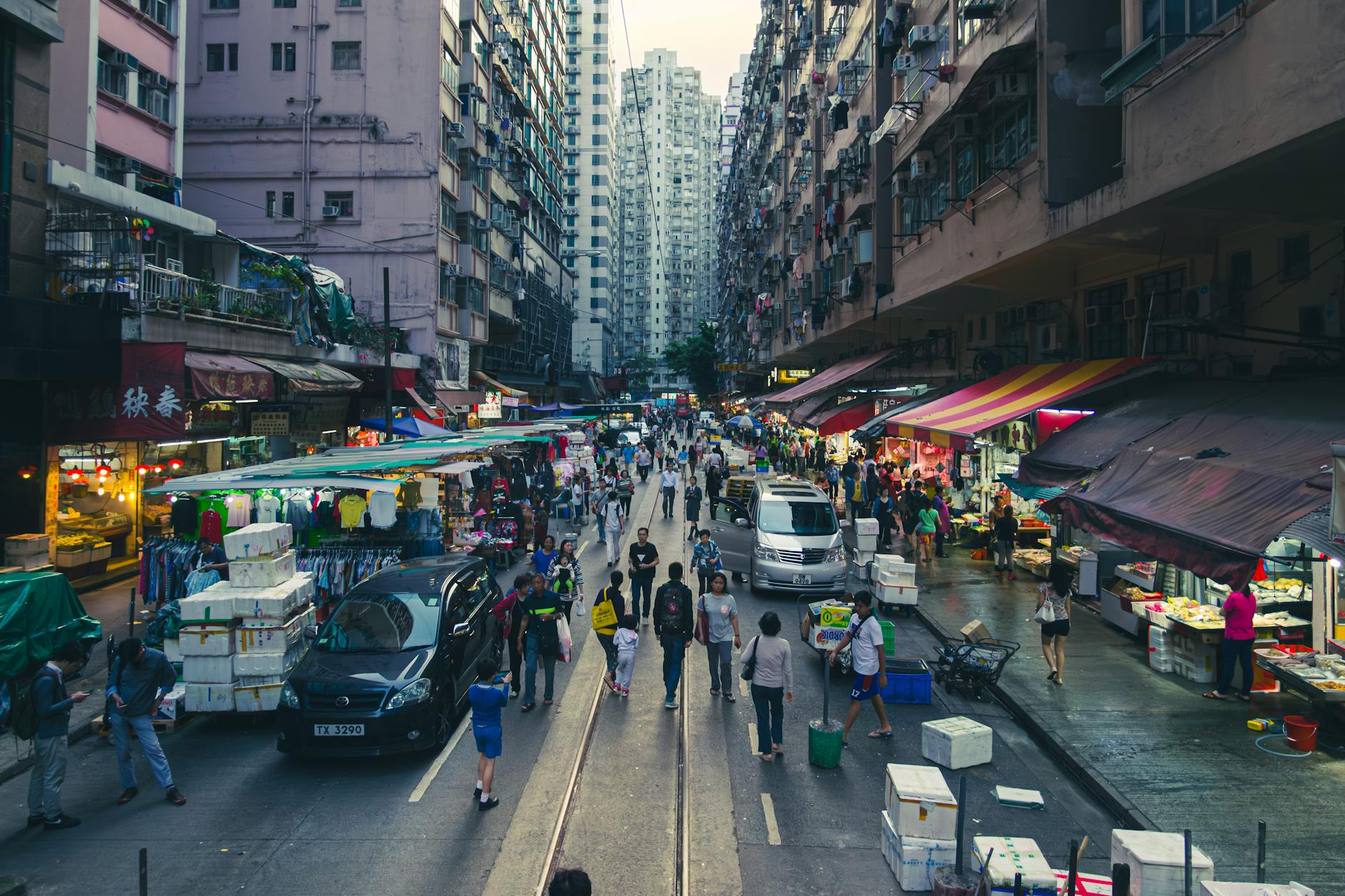 Vibrant scene of bustling Hong Kong street market during twilight, showcasing local life and commerce.