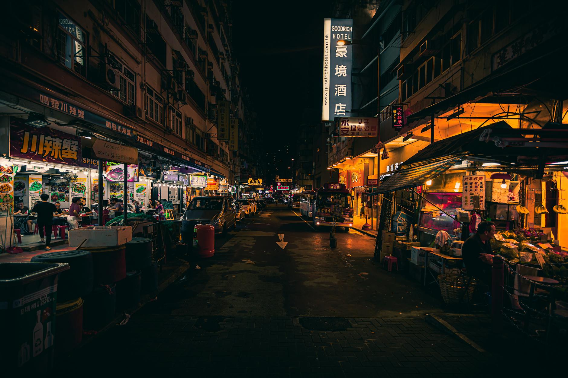 Explore the vibrant night street market scene in downtown Hong Kong filled with lights and activity.