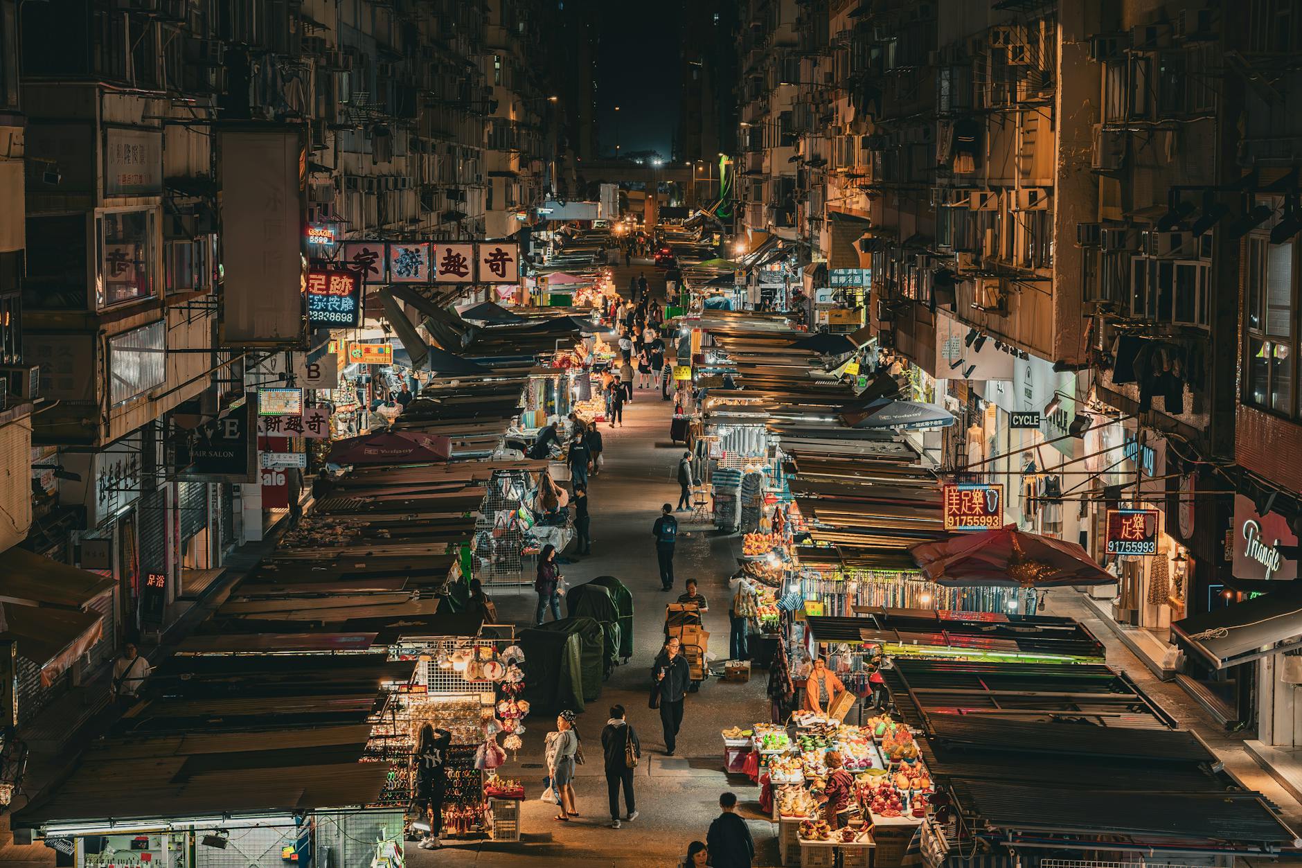 Explore the bustling night market in Mong Kok, Hong Kong, illuminated with vibrant street life.