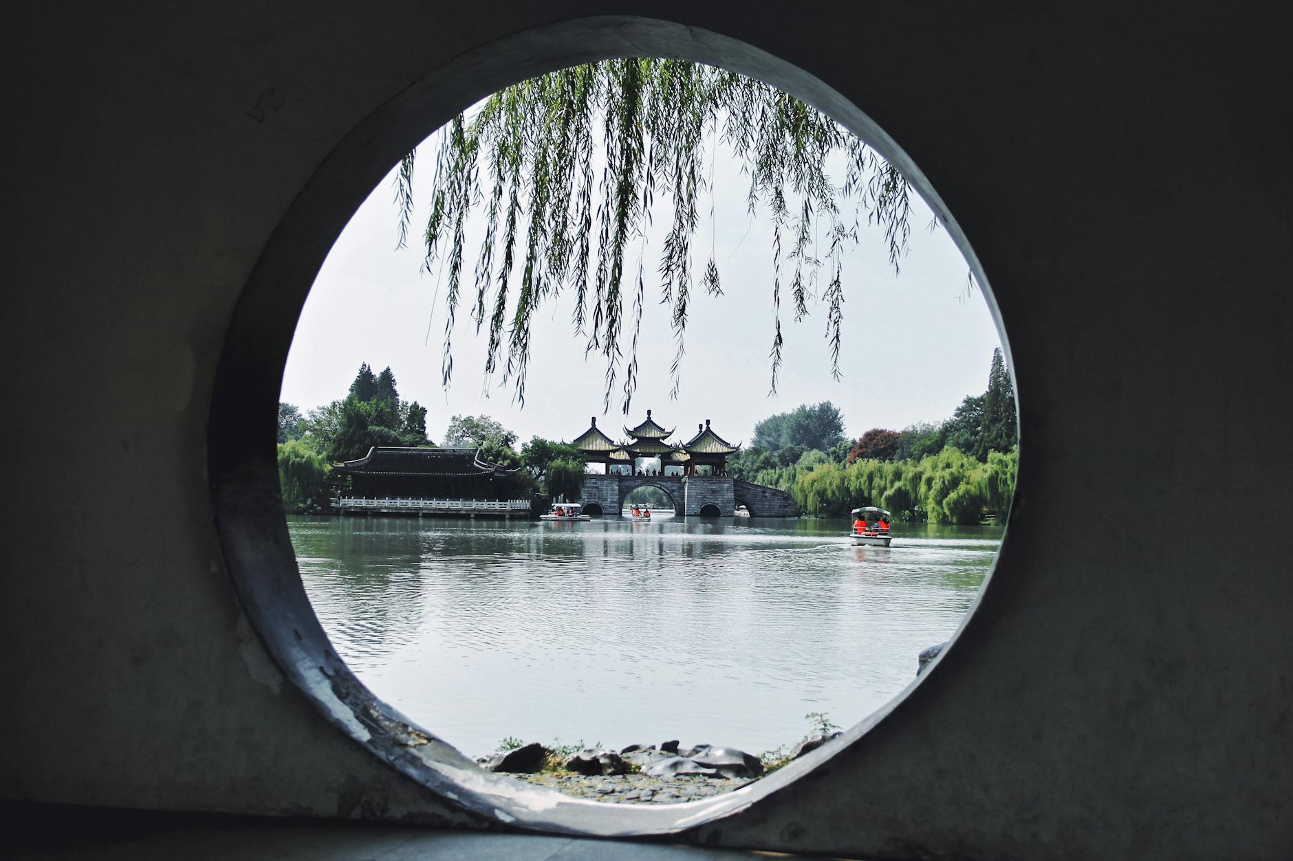 Elegant view of Wuting Bridge through a circular opening at Slender West Lake, Yangzhou, China.