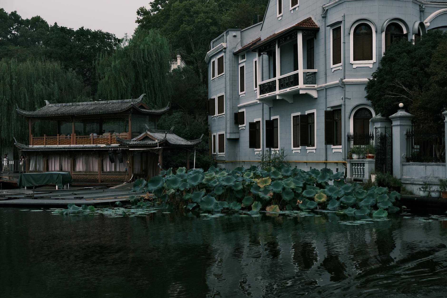 Explore serene Chinese architecture by a calm lake, capturing timeless beauty and harmony with nature.