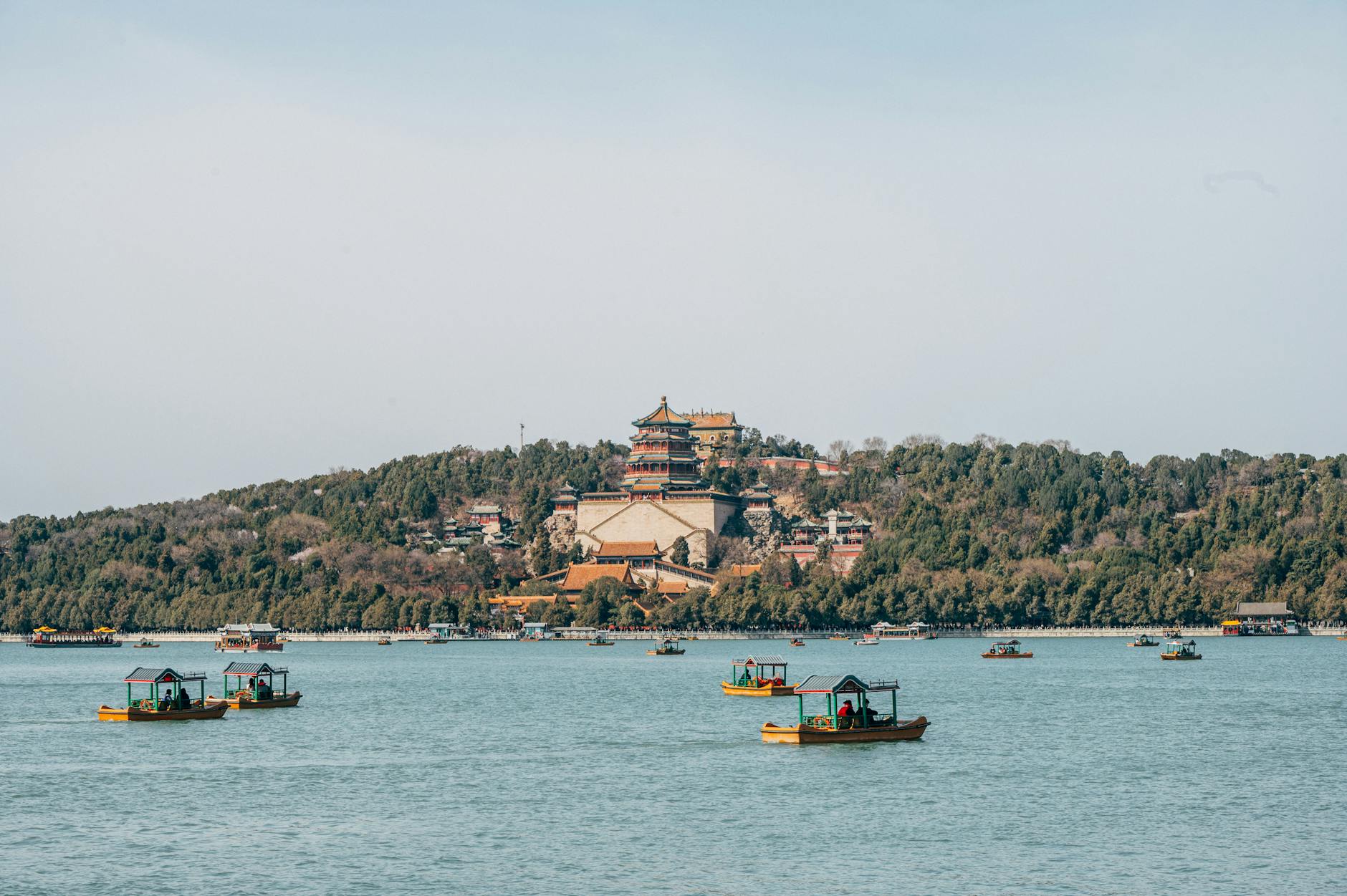 A beautiful view of the Summer Palace in Beijing, with boats on the lake during daylight.