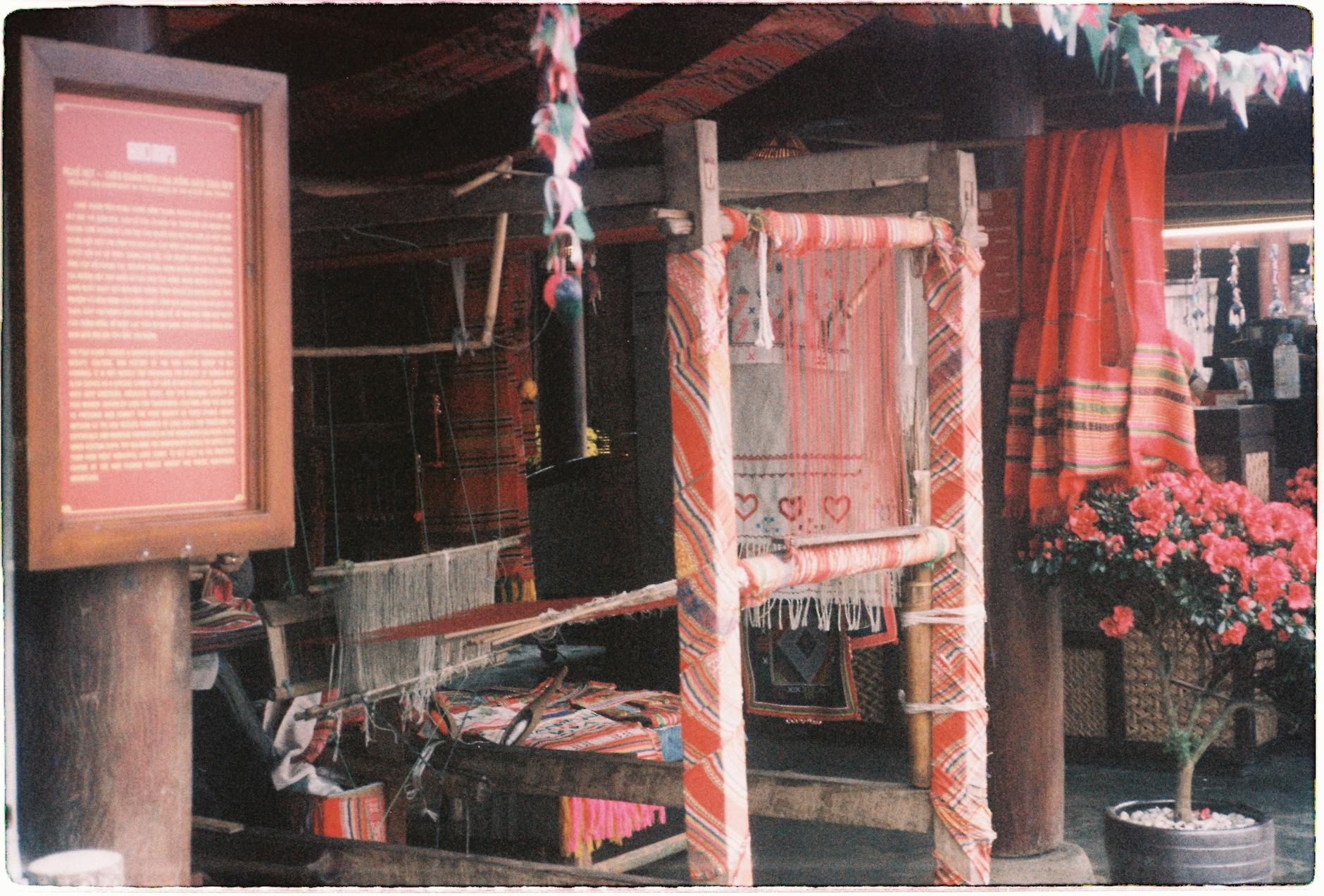 Colorful traditional weaving setup with textiles in a village in Lao Cai, Vietnam.