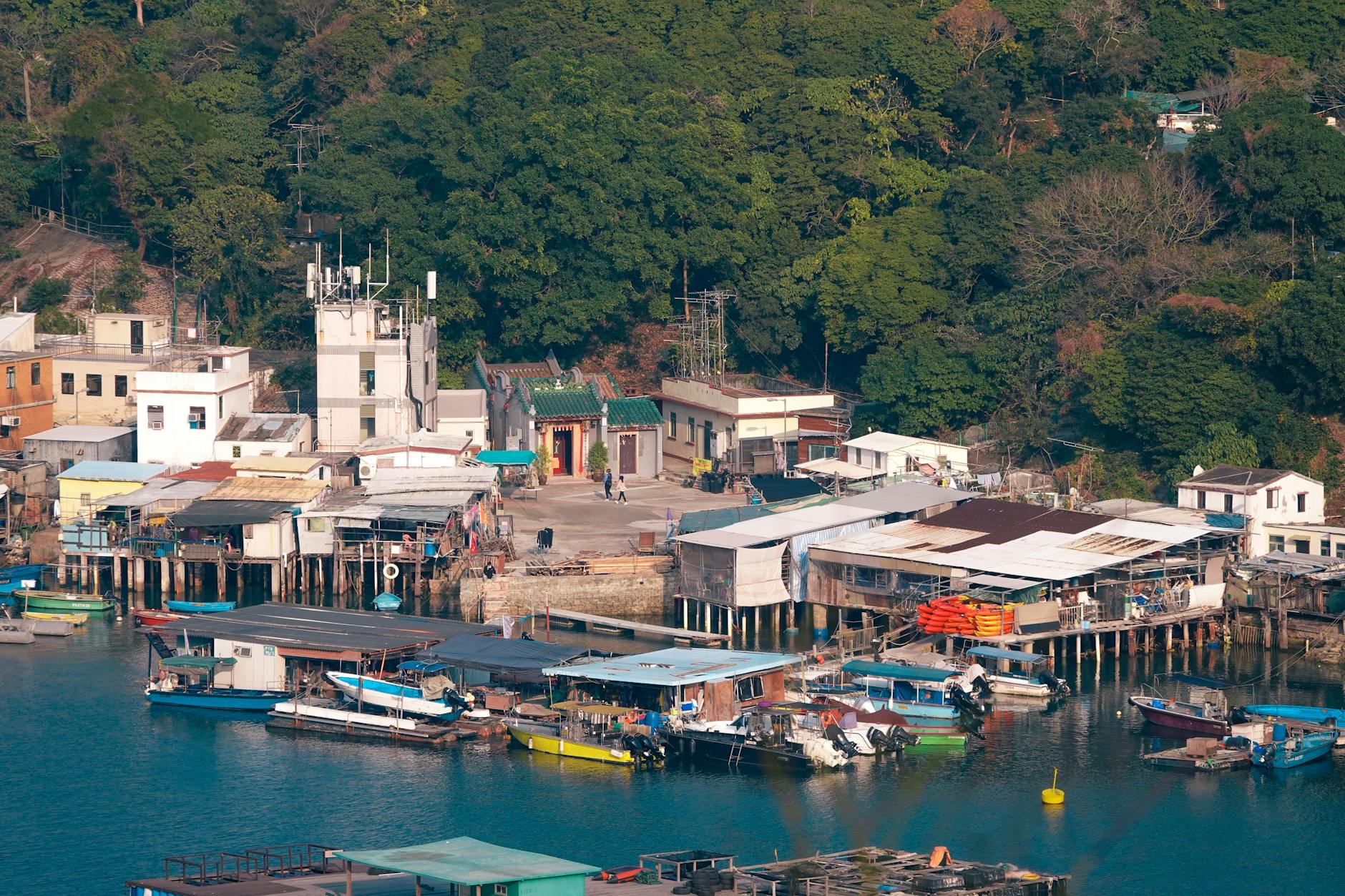 Charming Po Toi O village with colorful boats in a serene Hong Kong bay.