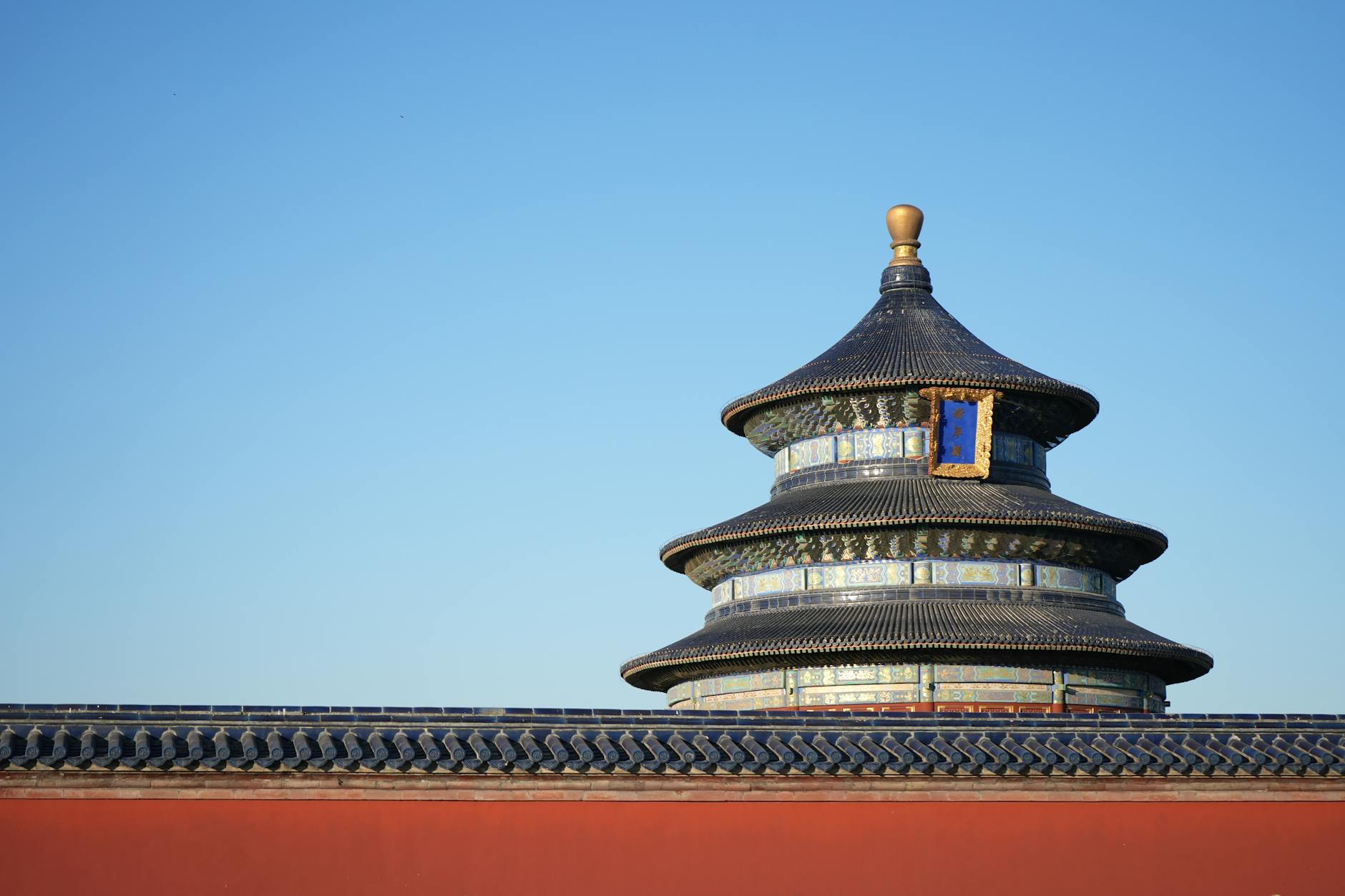 The iconic pagoda of the Temple of Heaven in Beijing, China stands against a clear, blue sky.