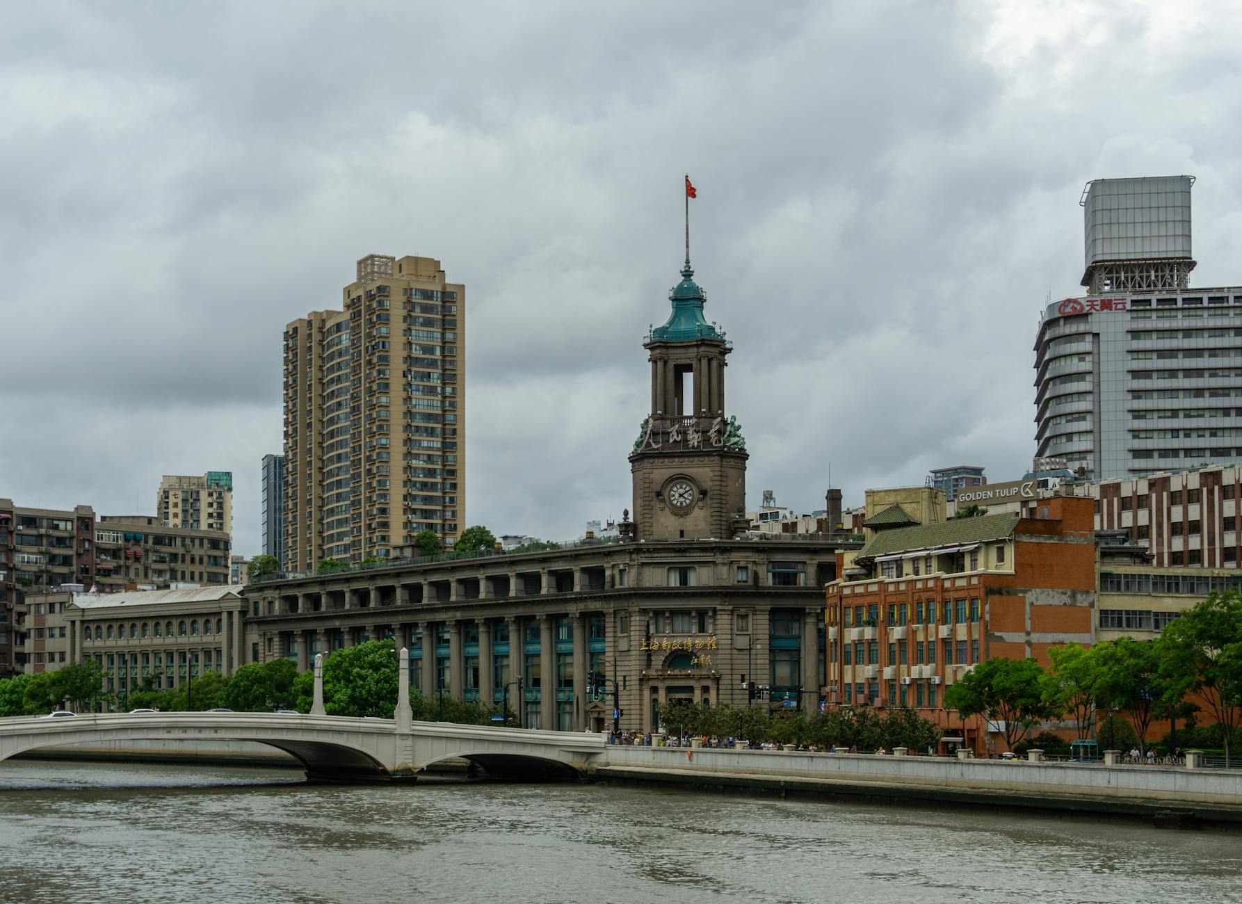 Urban skyline of Shanghai featuring a classic post office building by the river.