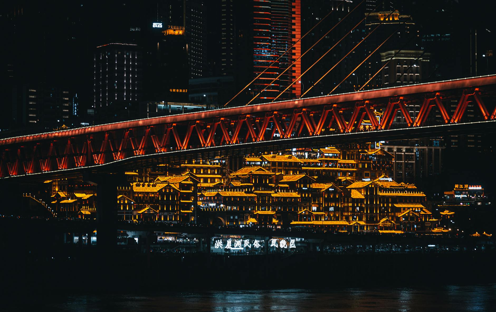 Stunning night scene of Chongqing's illuminated skyline featuring Qiansimen Bridge.