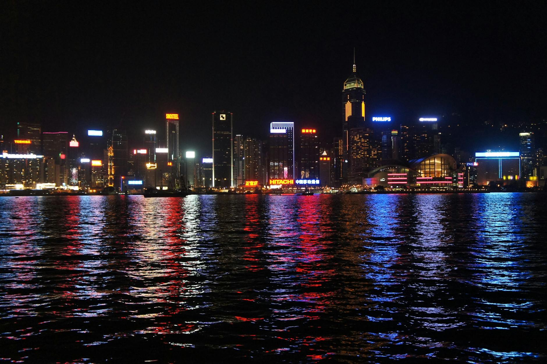 Stunning nighttime view of Hong Kong skyline reflecting on the water, showcasing vibrant city lights.