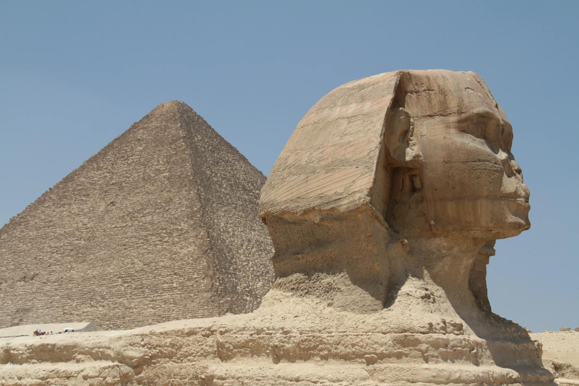 The Great Sphinx and Pyramid of Giza under a clear blue sky, capturing ancient Egypt's historical essence.
