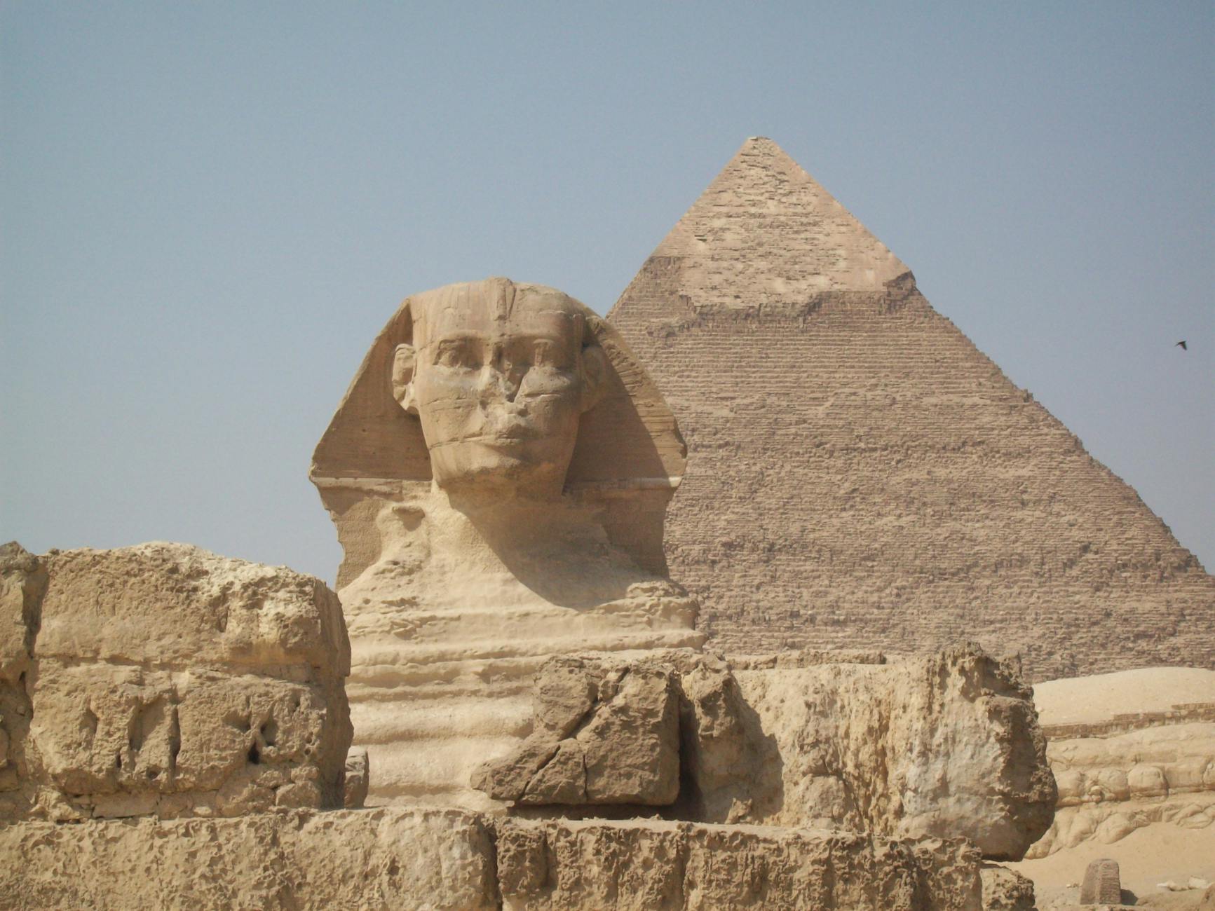 View of the Great Sphinx and Pyramid in Giza, Egypt, under a clear sky.