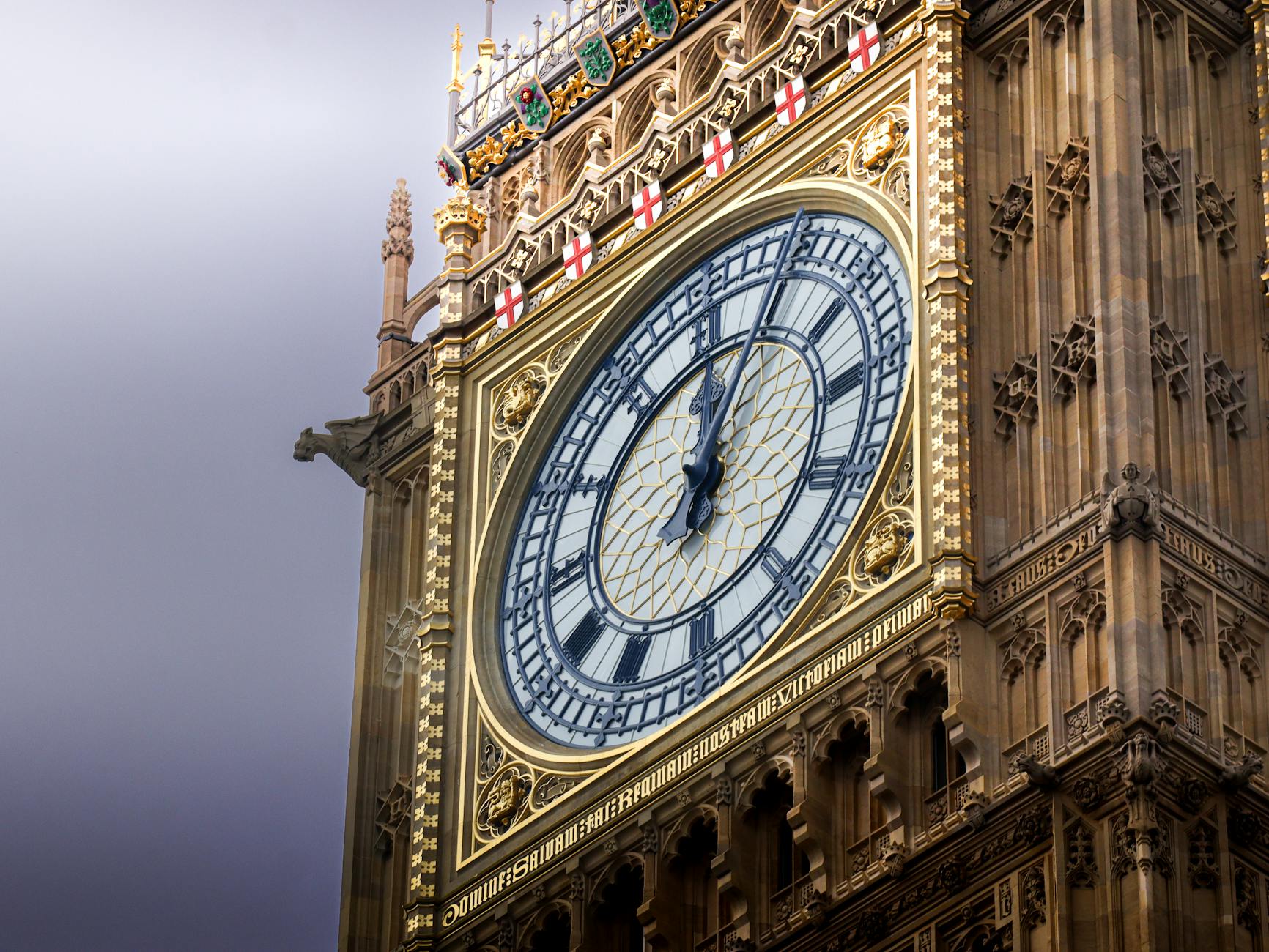 Detailed view of the iconic Big Ben clock face on a cloudy day in London, England.
