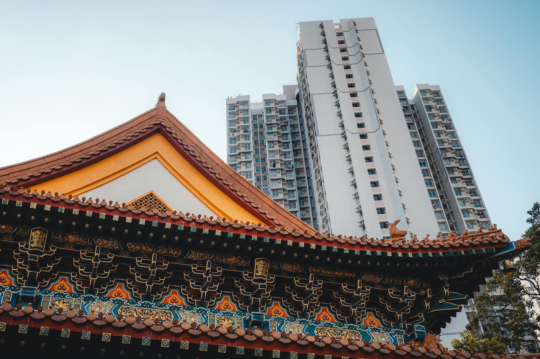 Ancient temple architecture contrasted with modern skyscraper in Hong Kong.