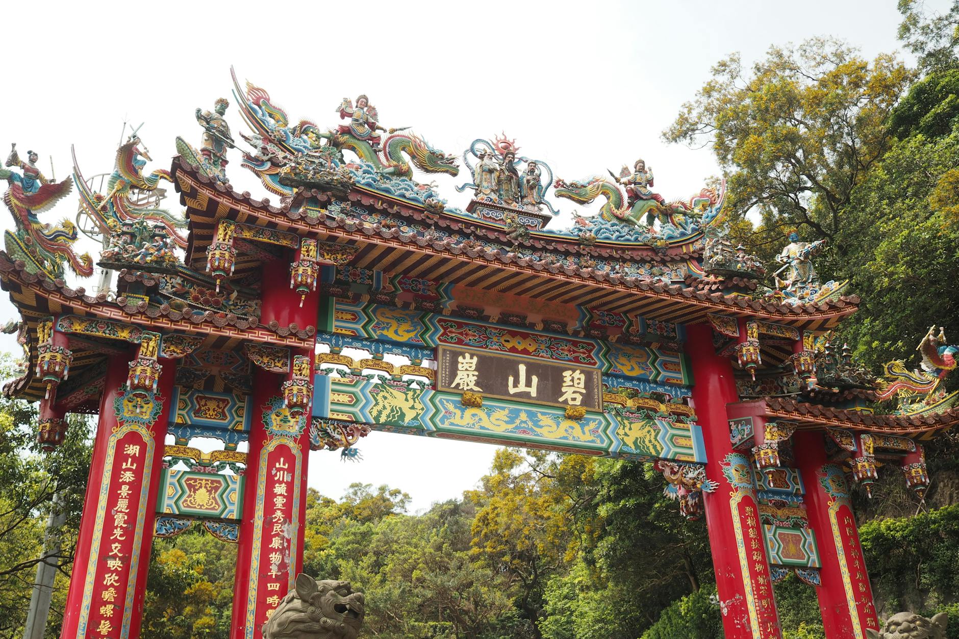 Vibrant and ornate Chinese temple gate with intricate dragon sculptures.
