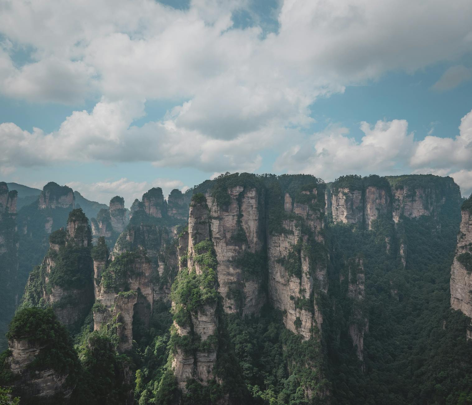 Stunning view of Zhangjiajie's iconic sandstone pillars under a cloudy sky.
