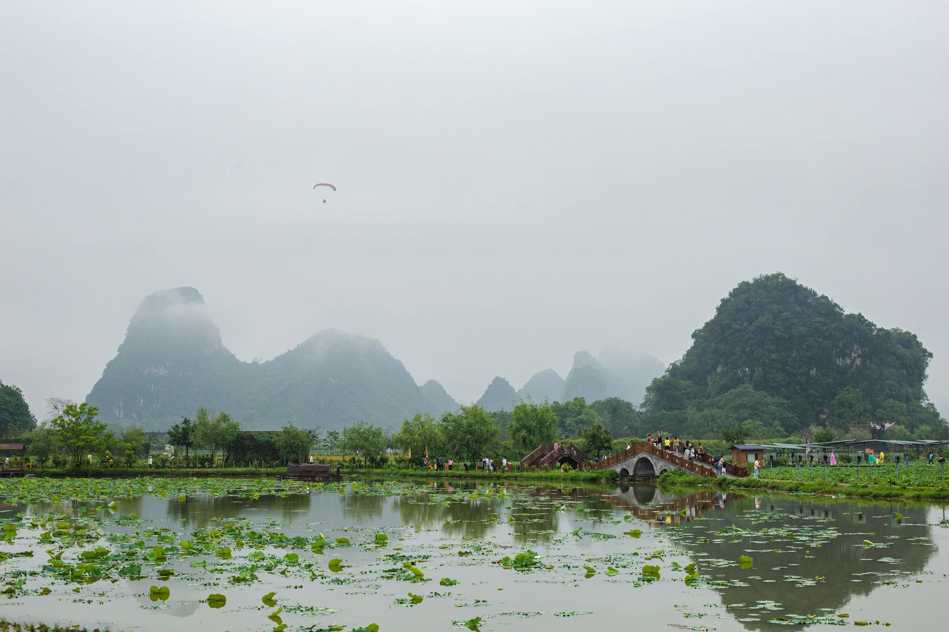 A picturesque misty landscape featuring a historical bridge and lush greenery in Vietnam, perfect for travel promotion.