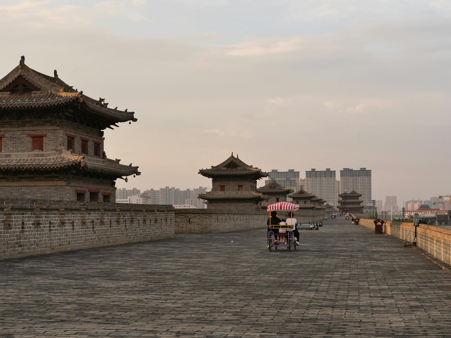 Cyclists enjoy a ride along the historic Xi'an City Wall at sunset.
