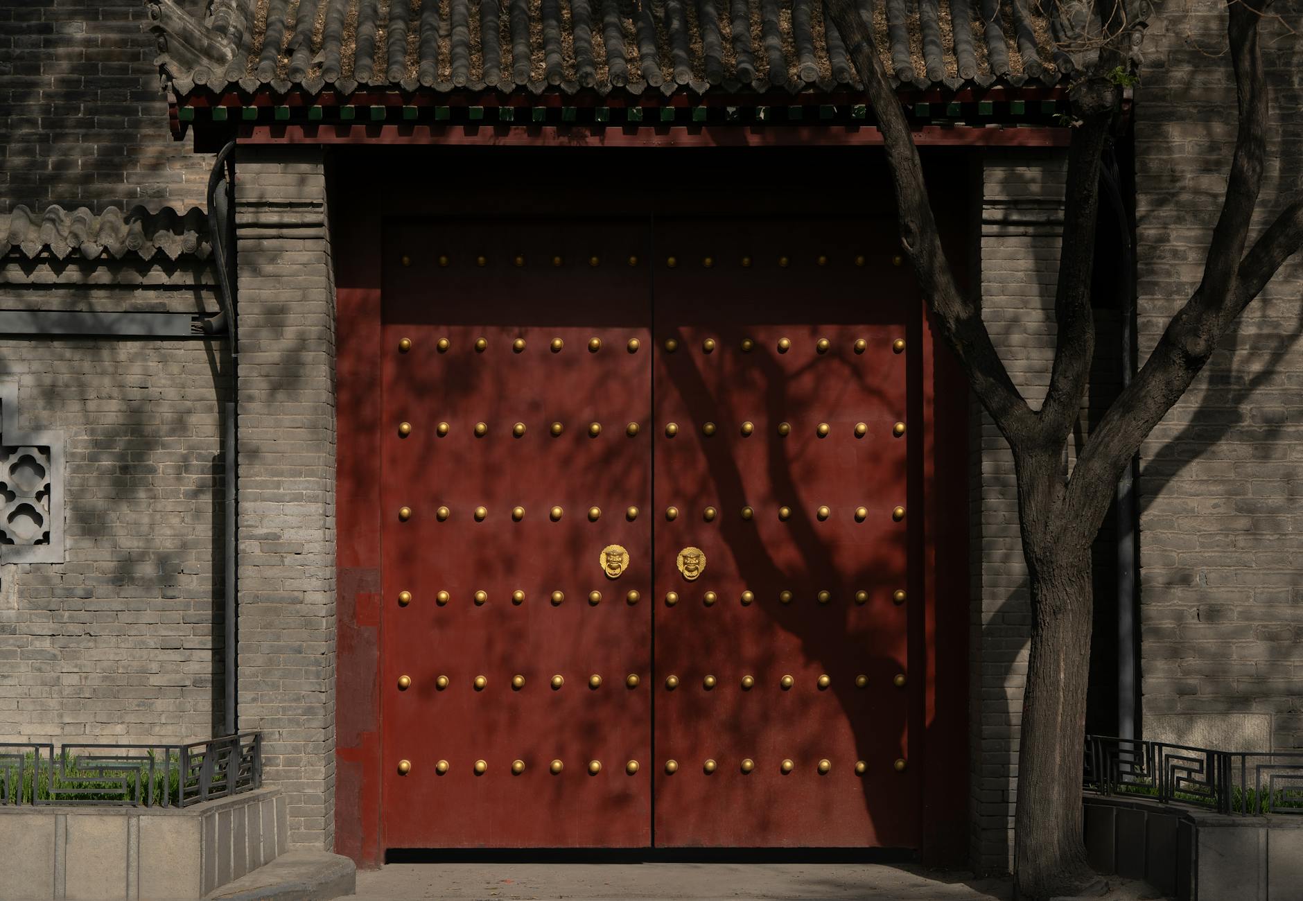 A historic red gate with gold studs, reflecting traditional Chinese architecture and culture.