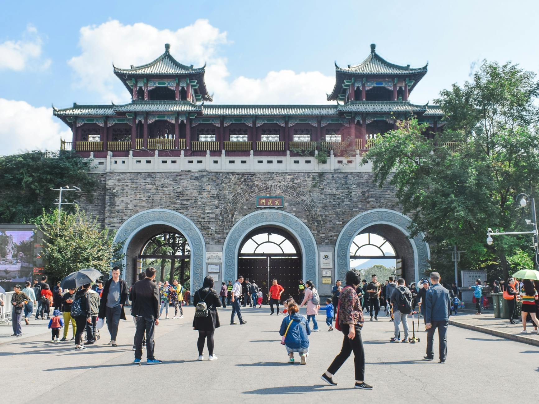 People exploring the historic Zhonghua Gate in Nanjing, China on a bright day.