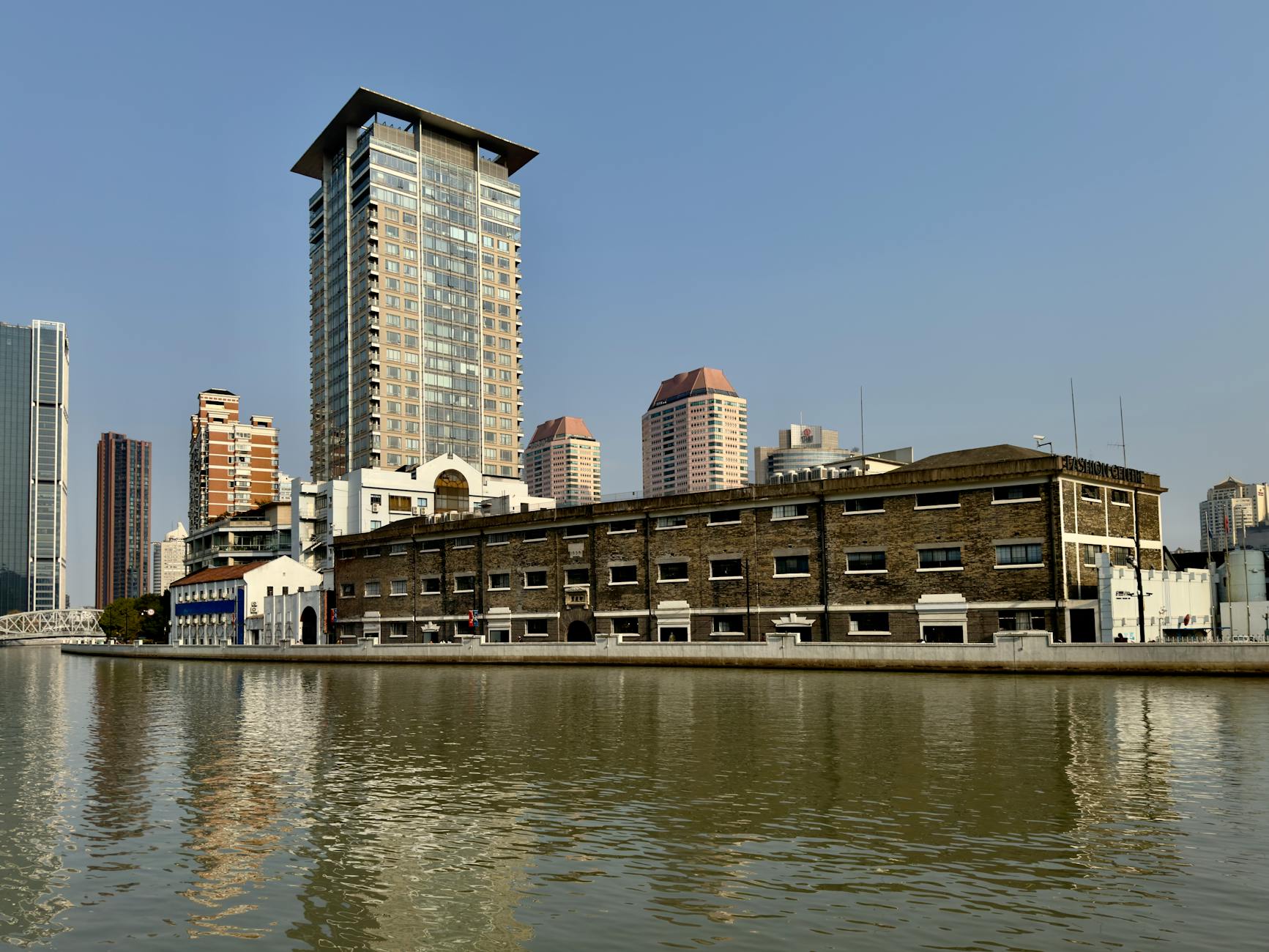 Stunning urban skyline featuring skyscrapers along Suzhou Creek in Shanghai during the day.