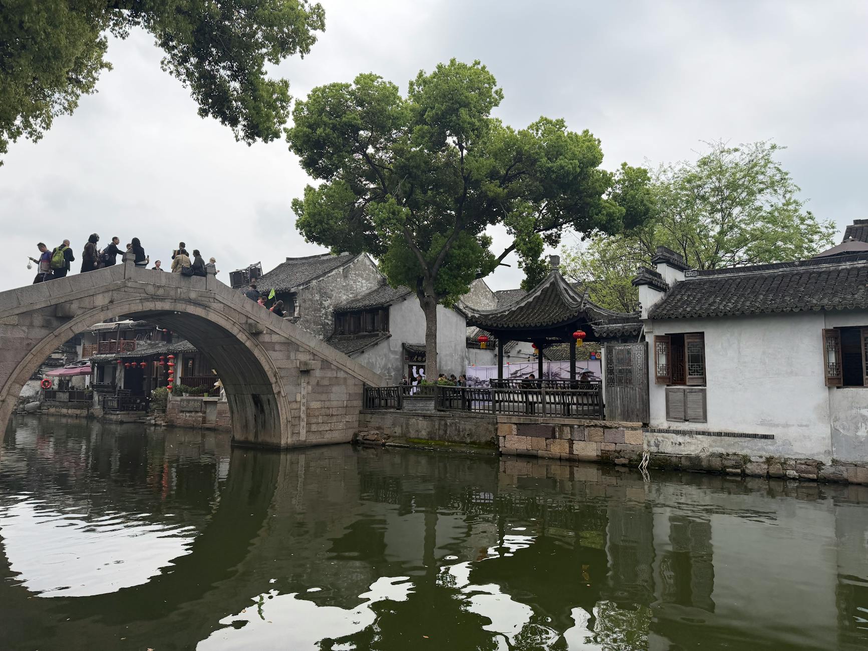 Scenic view of a traditional stone bridge and architecture in a Chinese water town.