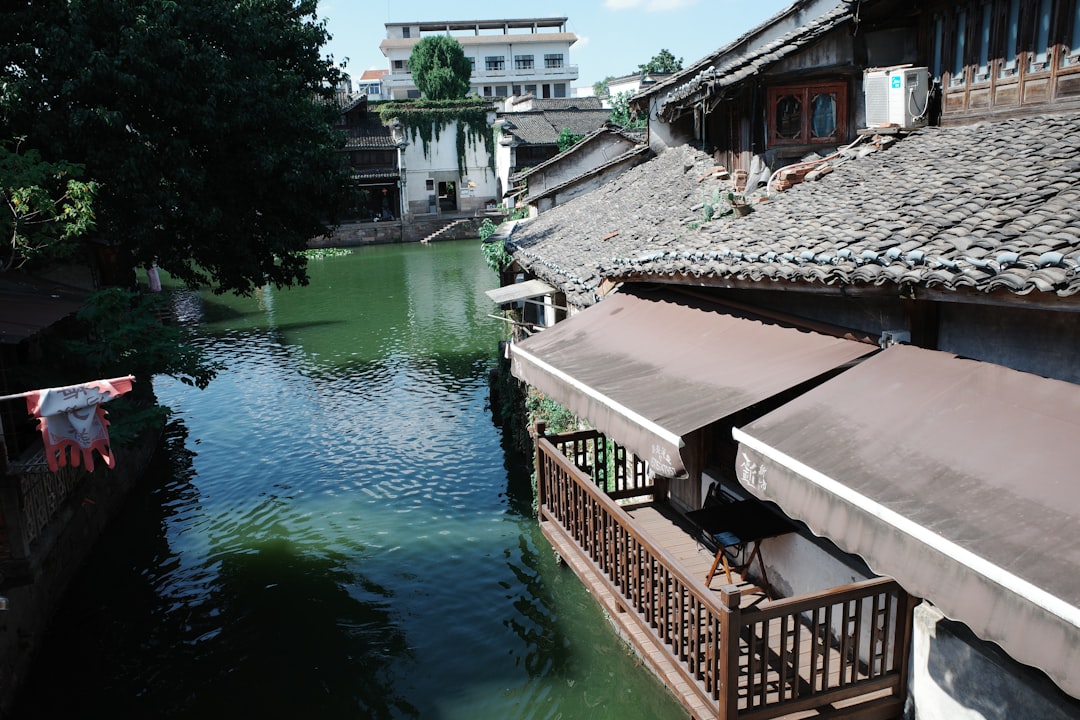 Riverfront buildings with traditional tiled roofs and awnings.