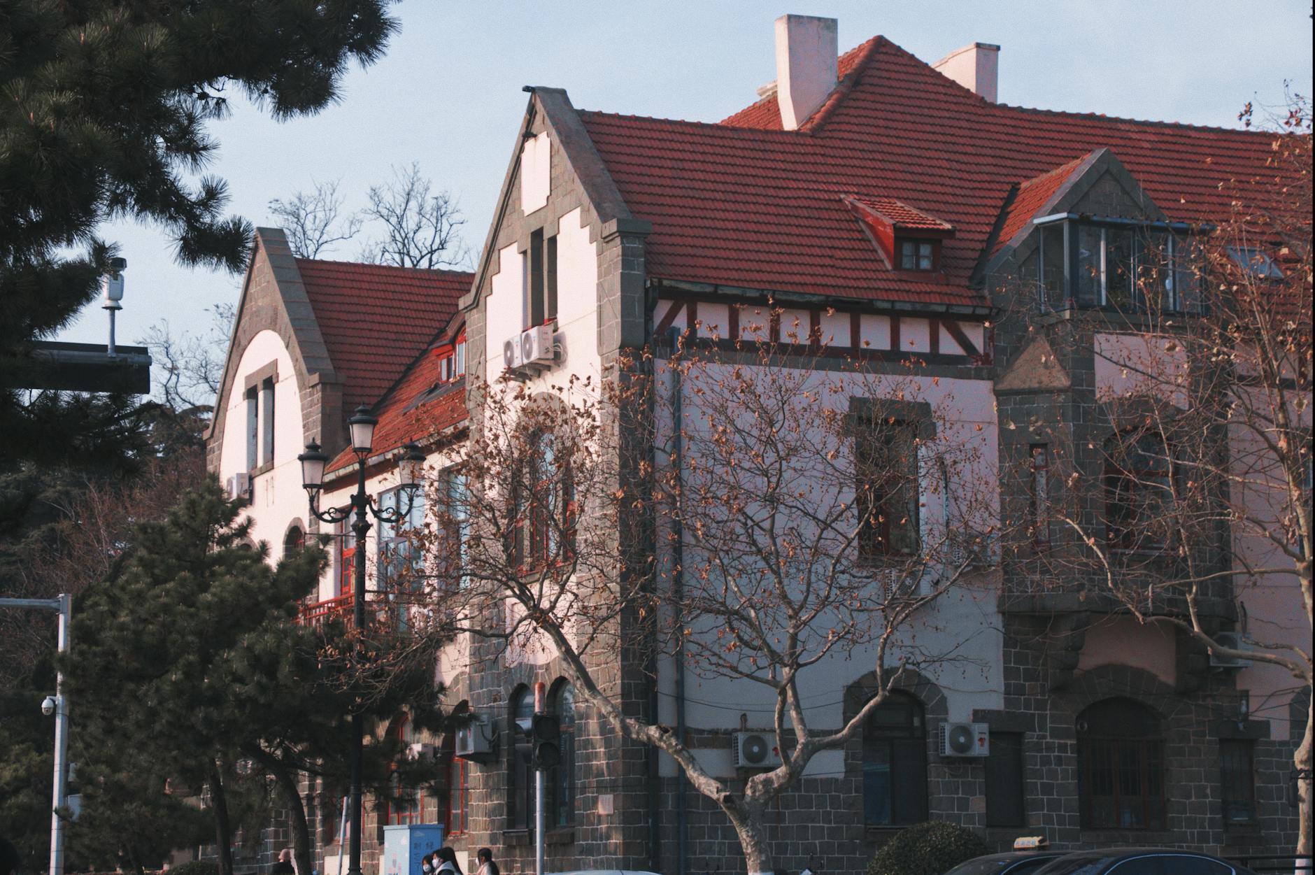 Elegant European-style houses with red roofs in a serene urban setting, capturing historic architecture.