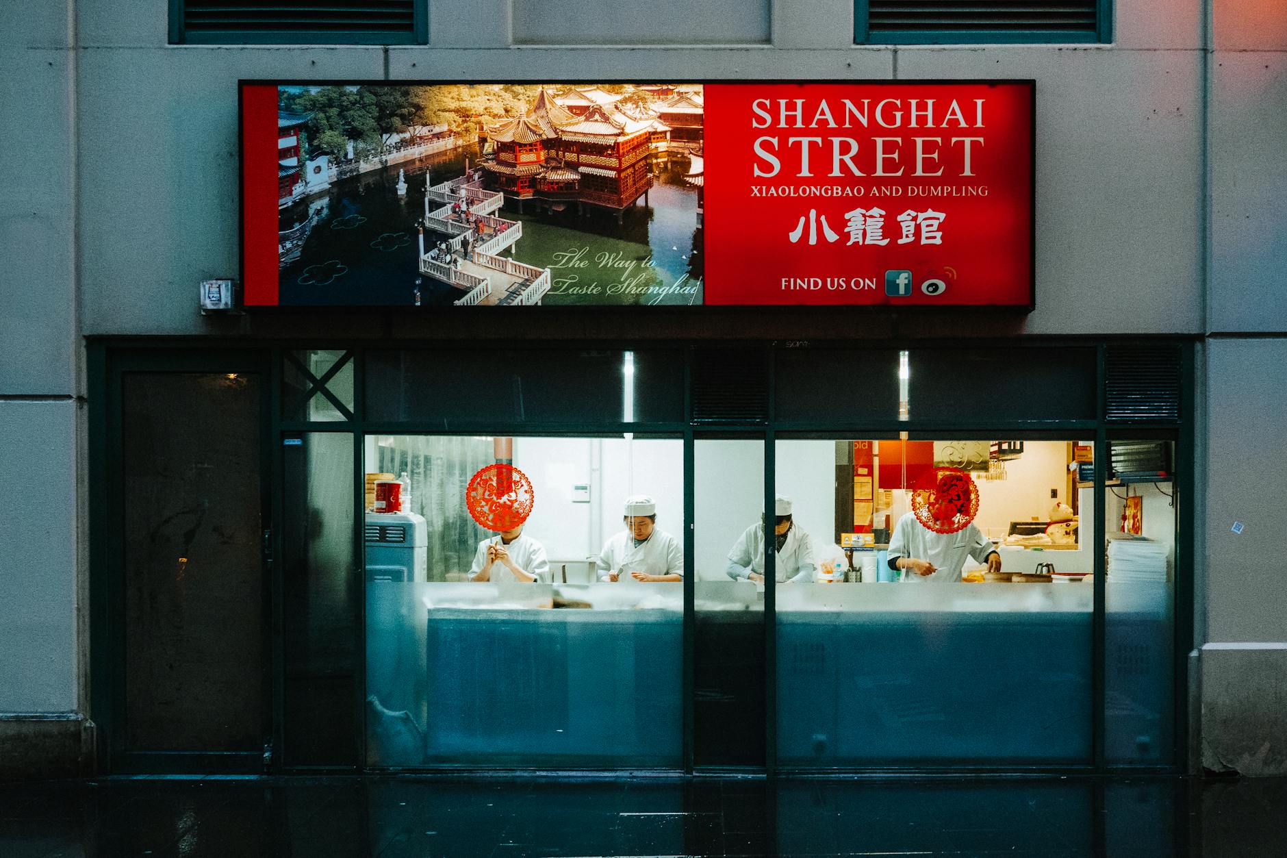 Three chefs prepare dumplings in a Melbourne Chinatown restaurant.
