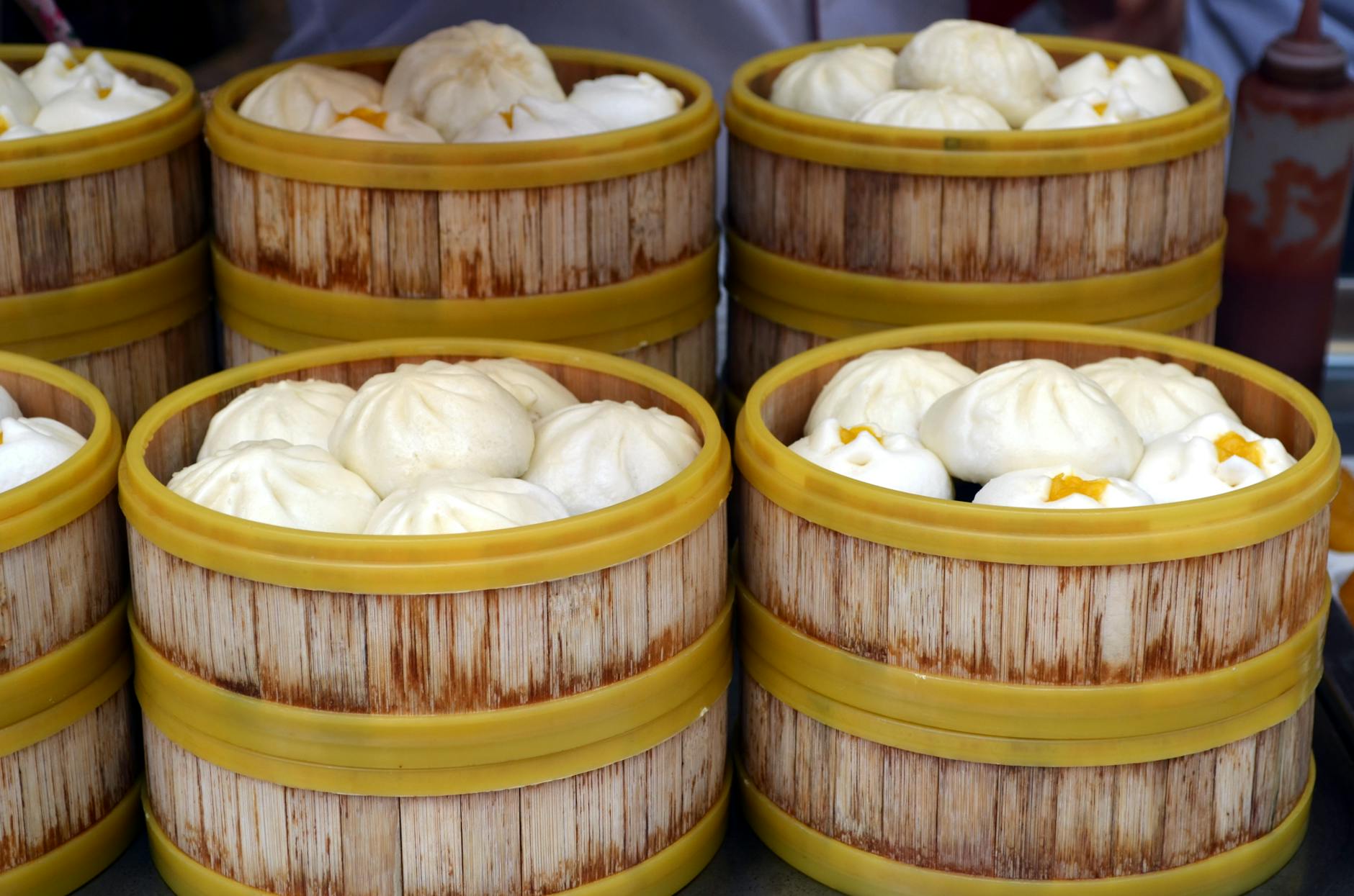 Close-up of steamed buns in traditional bamboo steamers, showcasing delicious Asian cuisine.