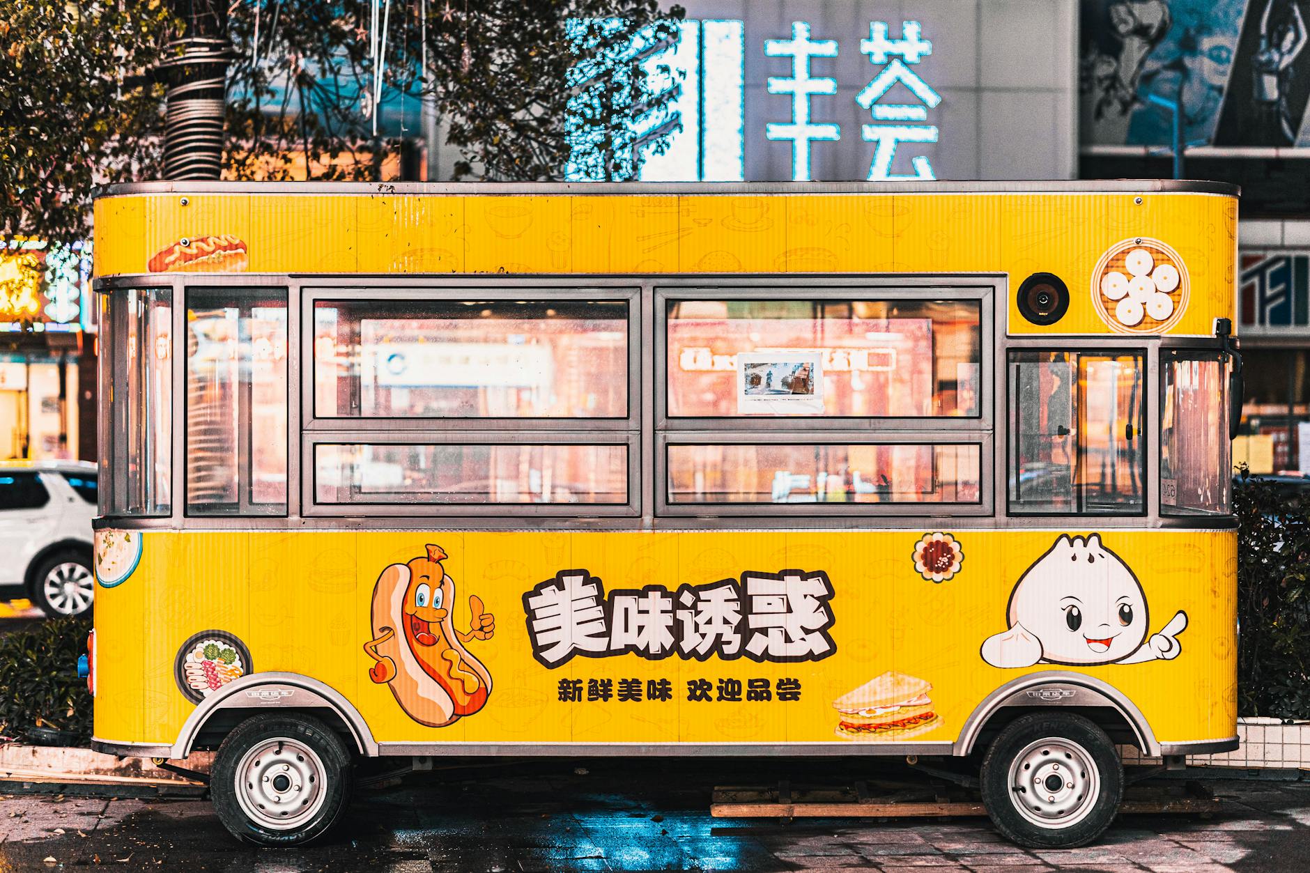 Colorful food truck with Asian script, offering street food in an urban setting.