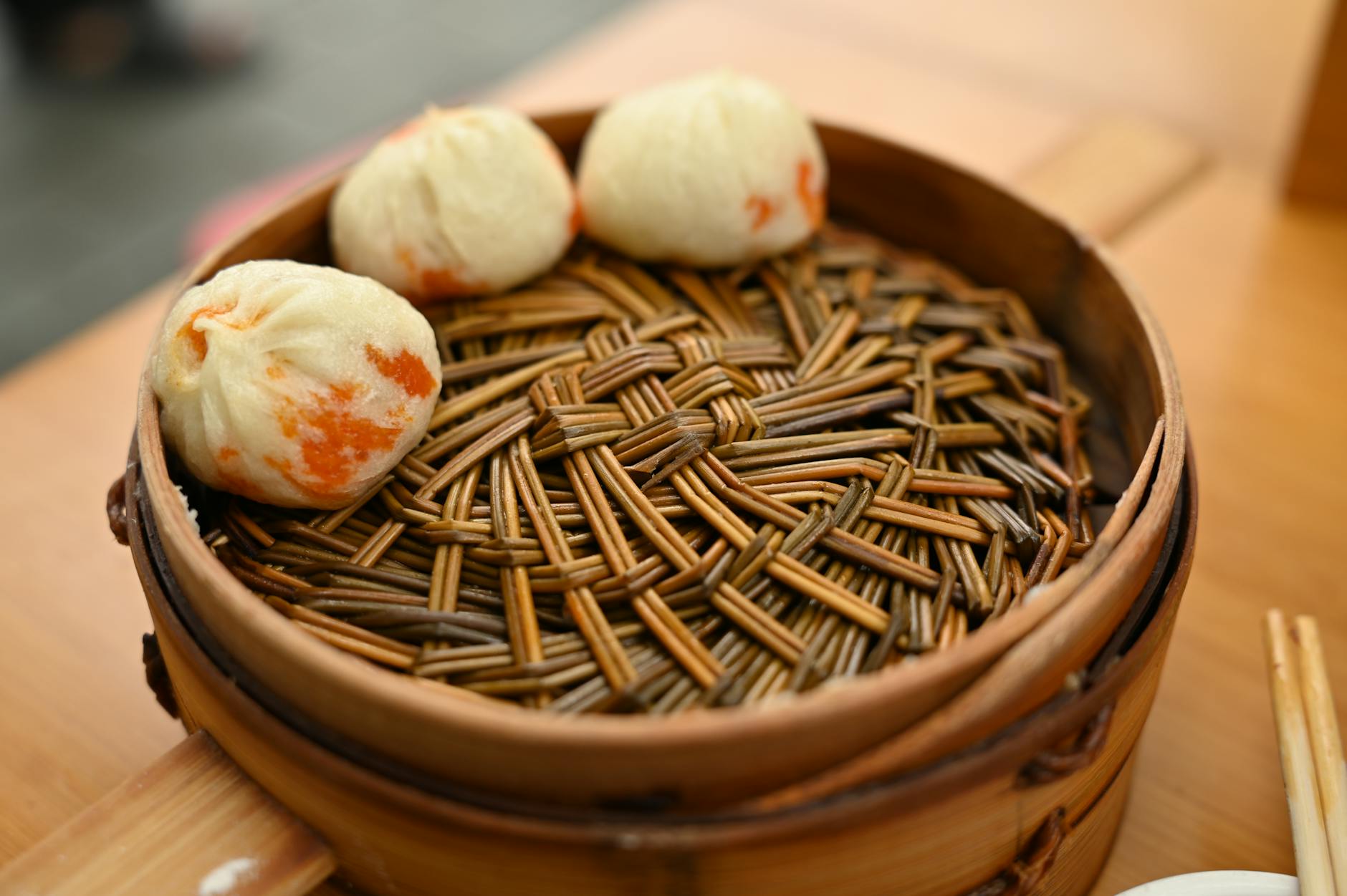 Steamed dumplings served in a traditional bamboo steamer basket, perfect for Asian cuisine themes.