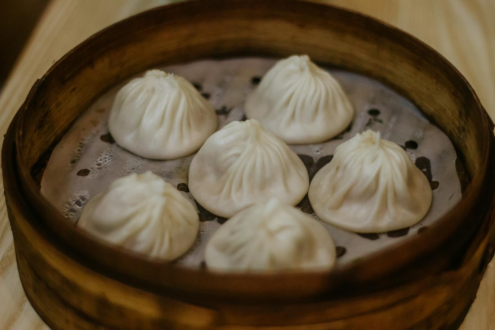 Close-up of steamed Chinese dumplings in a bamboo steamer, typical of Fuzhou, China cuisine.